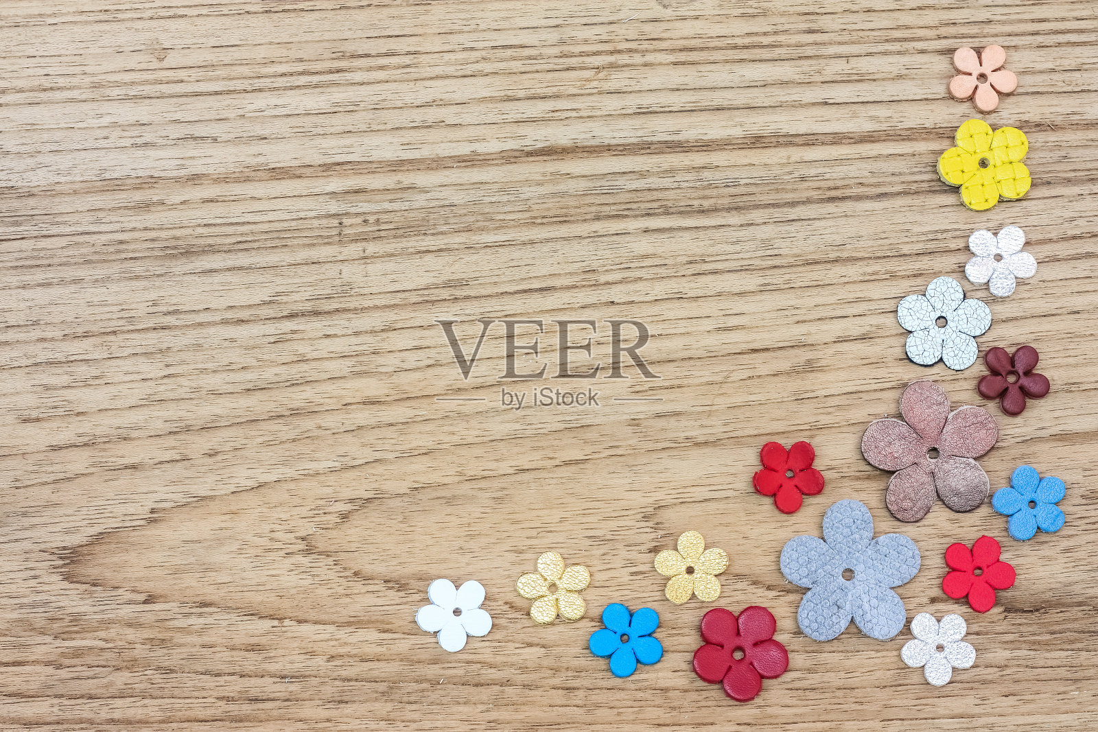 彩色的天然皮革花在木材背景与文本空间。照片摄影图片