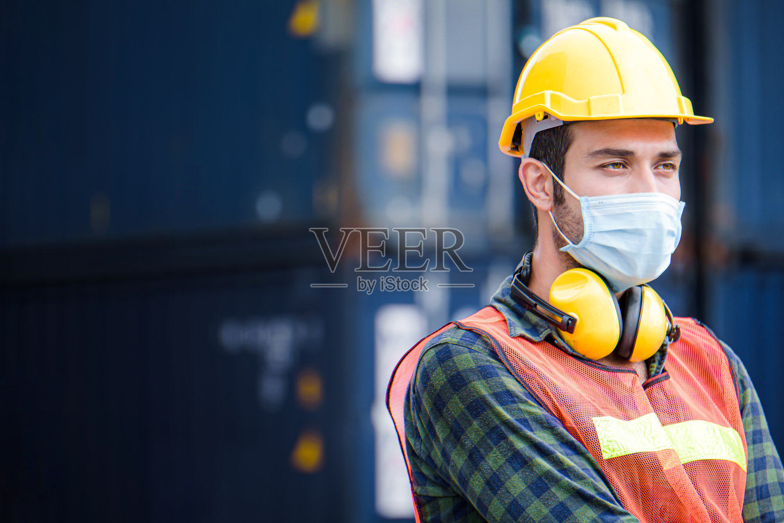 白种人工程师戴着黄色安全帽,检查控制装载集装箱集装箱从货船的进出口,运输照片摄影图片