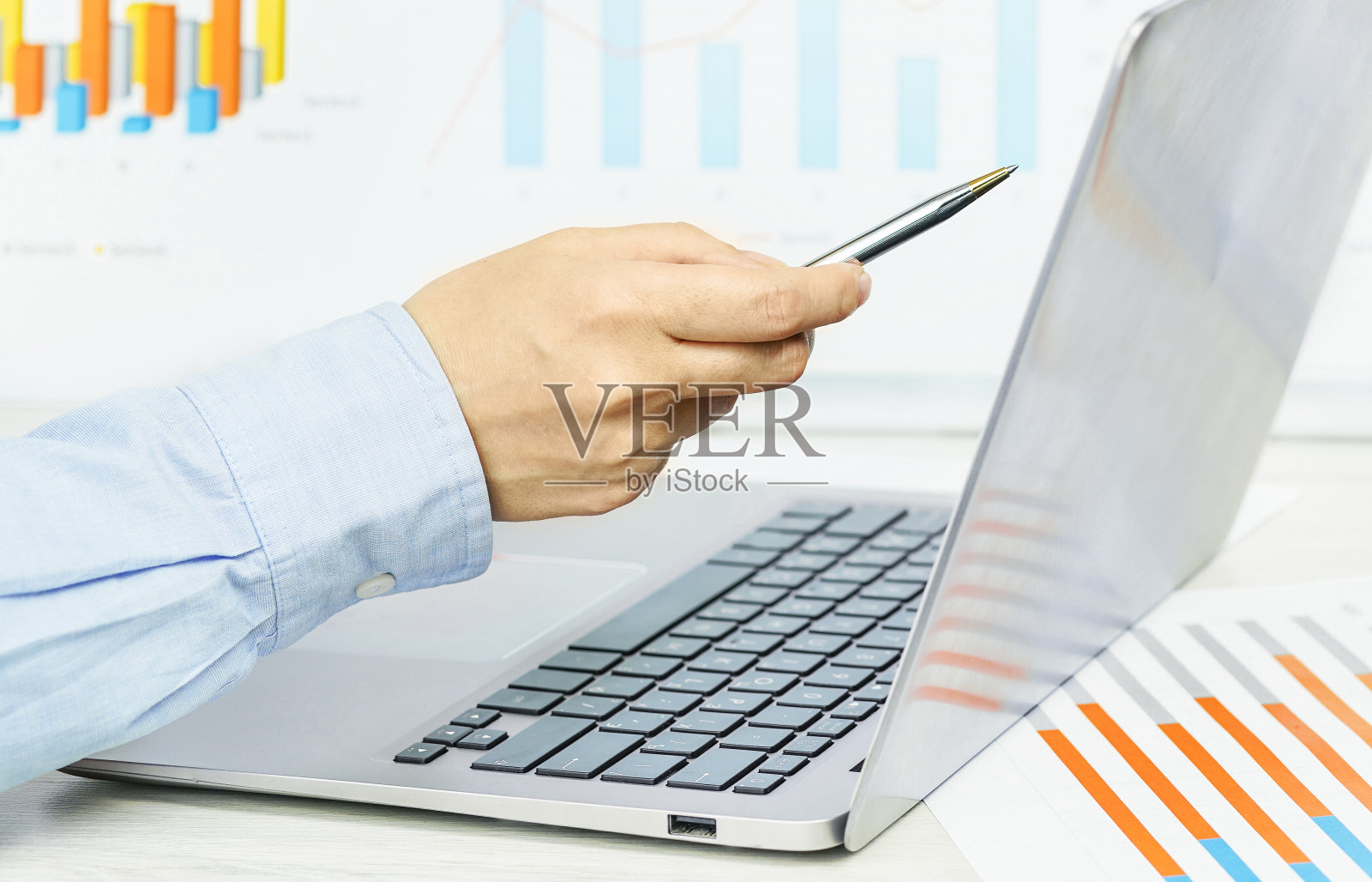 融资。女性手指着笔记本电脑屏幕上桌上的财务图表照片摄影图片