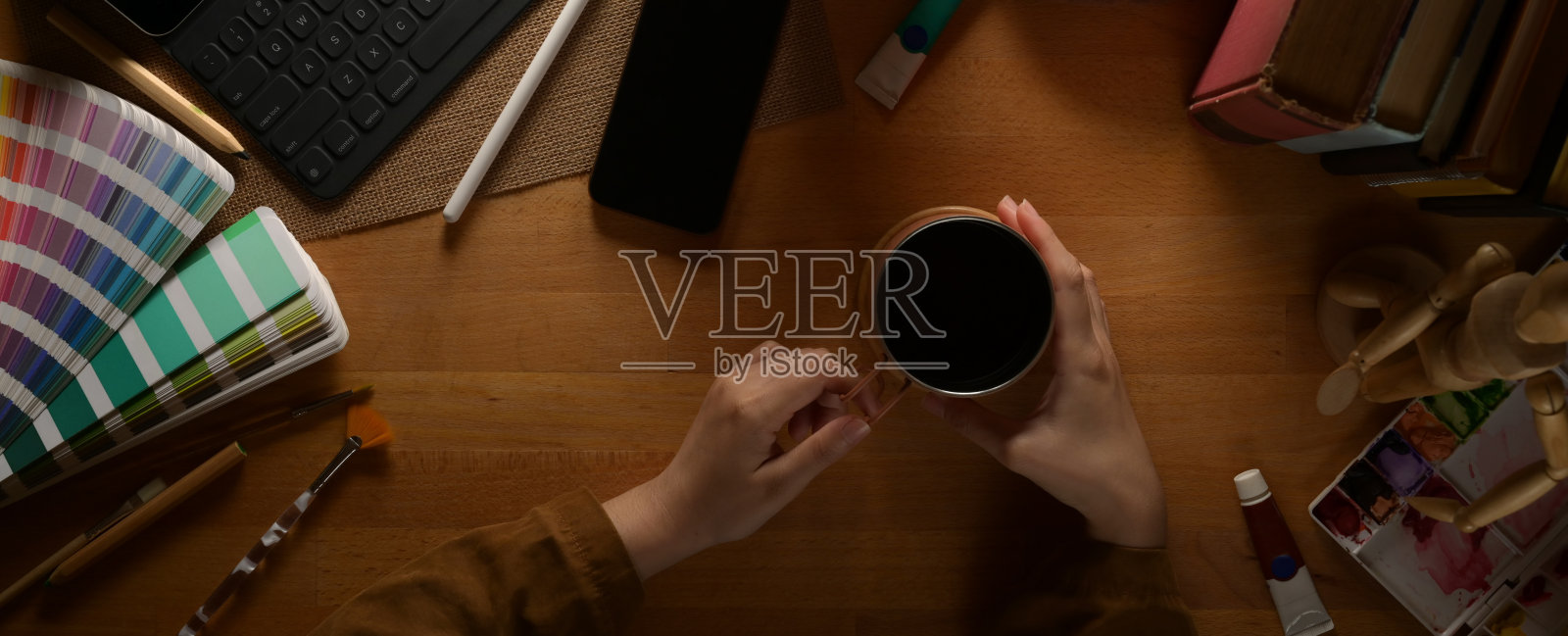 女设计师会在木桌上喝咖啡休息,用绘画工具和数码设备照片摄影图片