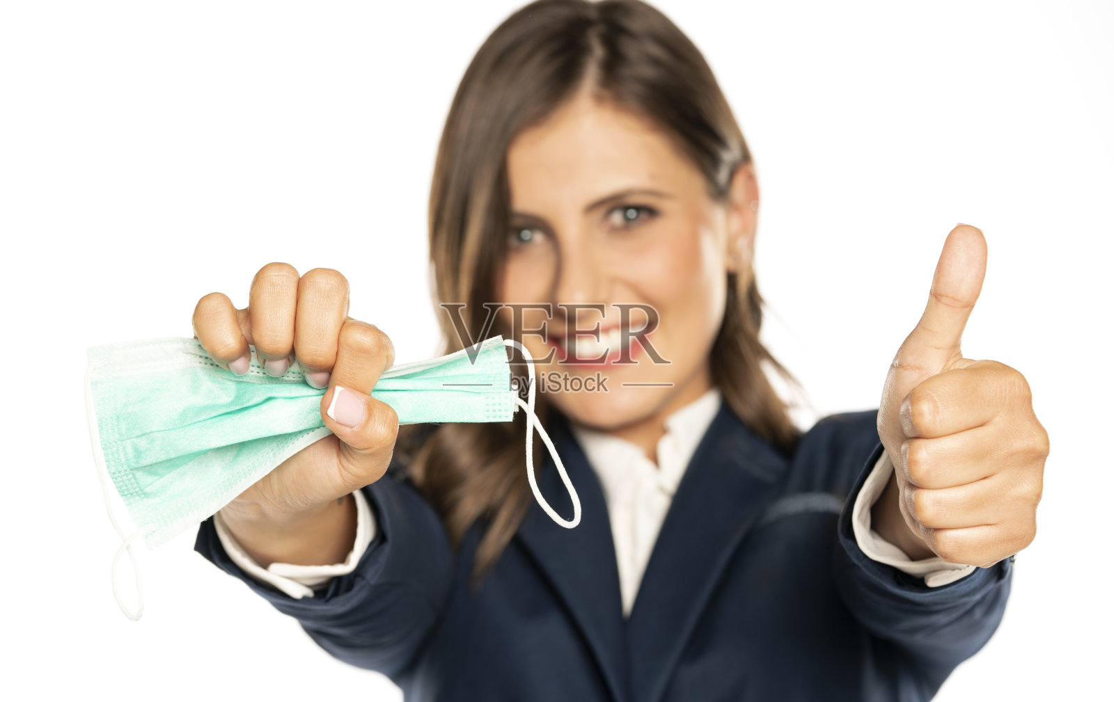 一个年轻快乐的女人拿着一个保护面罩,竖起大拇指照片摄影图片