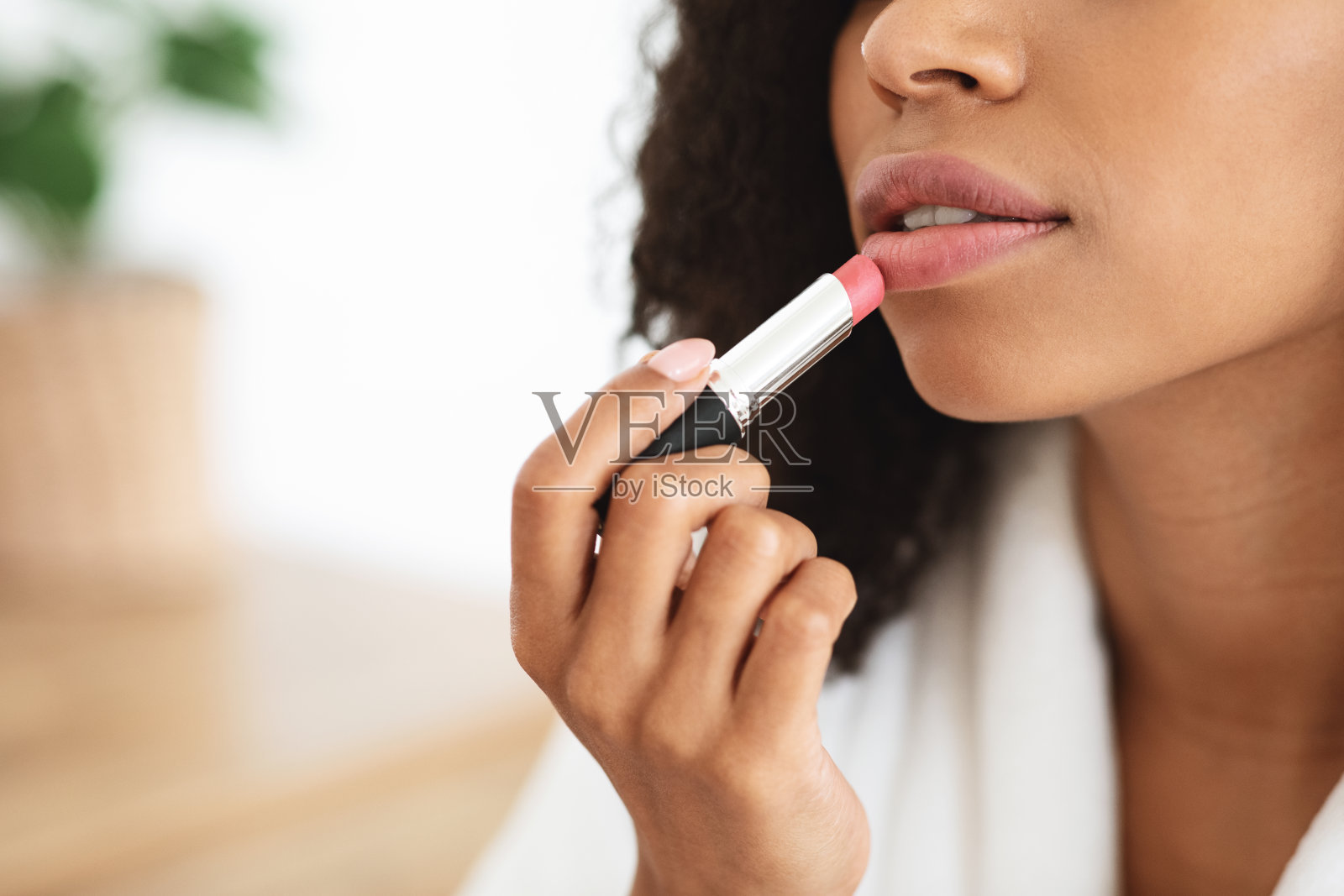 特写非洲裔美国妇女应用裸色口红,做日常化妆照片摄影图片