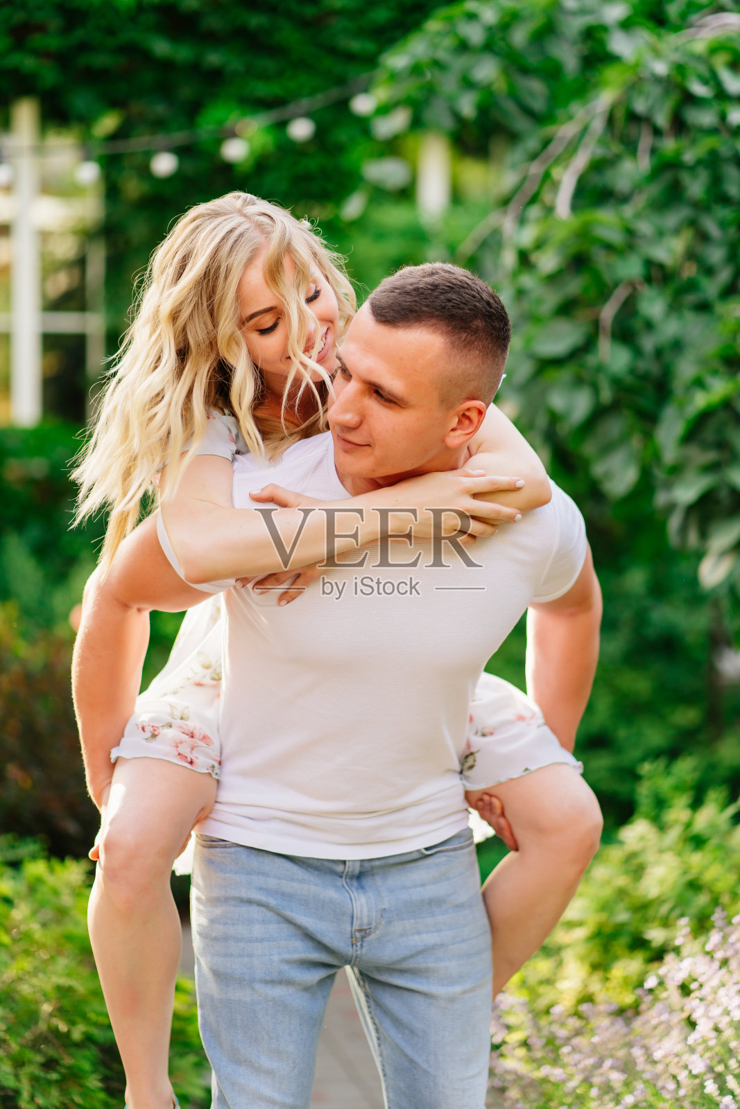 美丽和幸福的夫妇在花园里玩。照片摄影图片