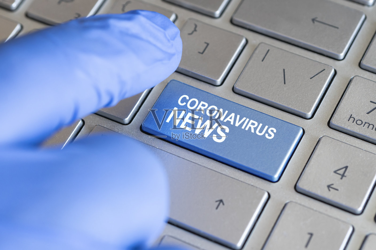 冠状病毒的概念。红色键盘和COVID-19信息。戴着蓝色手套的手指按下按钮。照片摄影图片