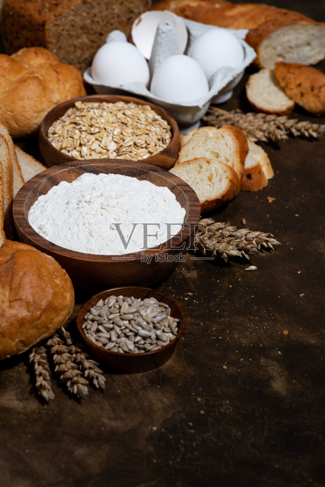 在深色背景上垂直放置各种烘焙食品和新鲜面包照片摄影图片