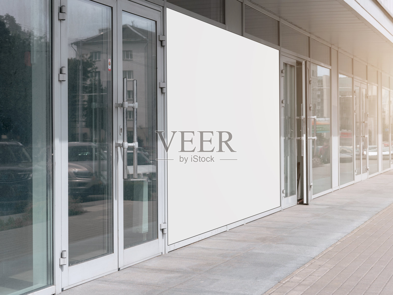 在城市街道的购物中心的玻璃墙上,大的促销空白的白色横幅和实物模型的位置照片摄影图片