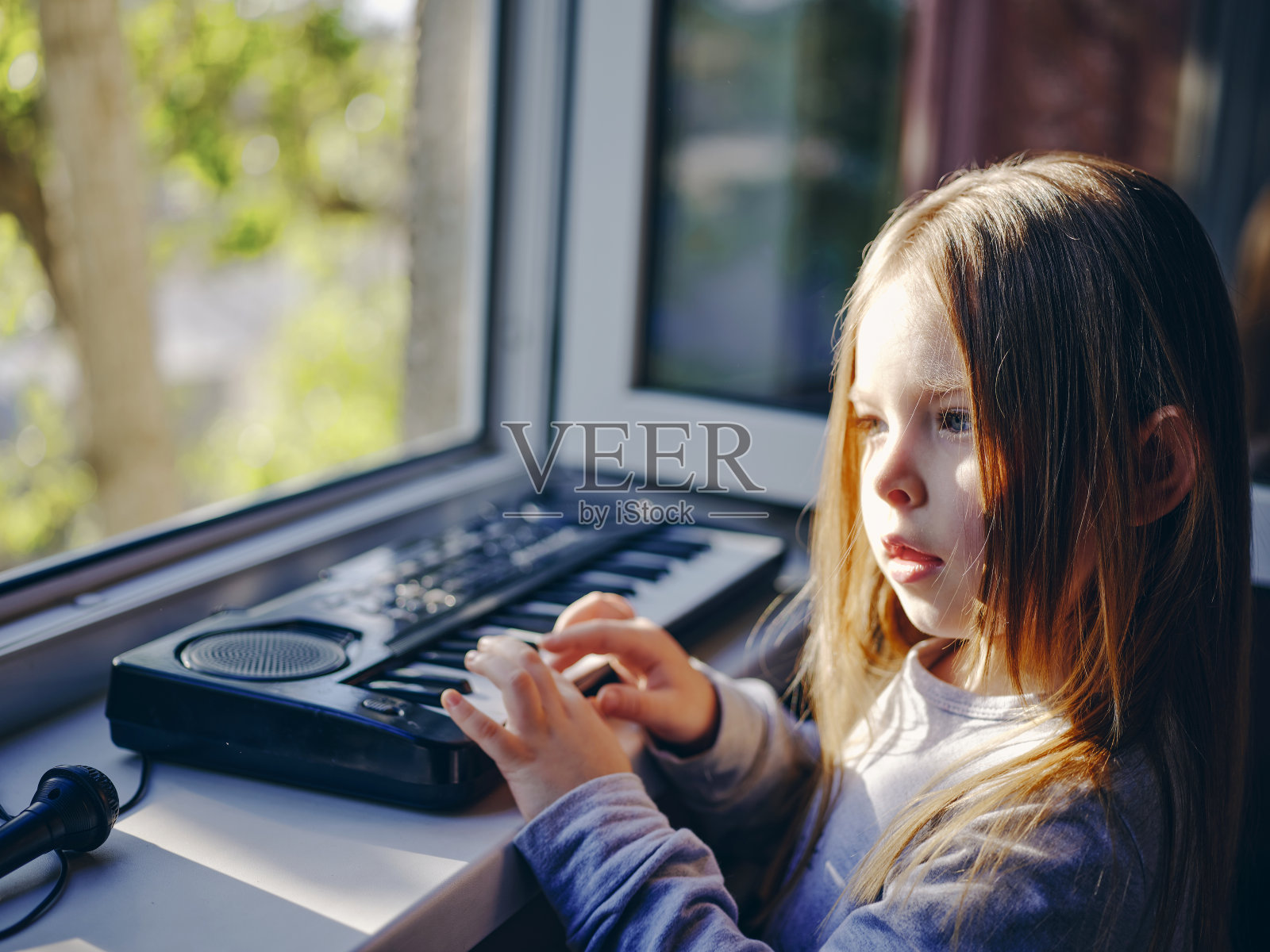 小卷毛女孩吹蒲公英。照片摄影图片