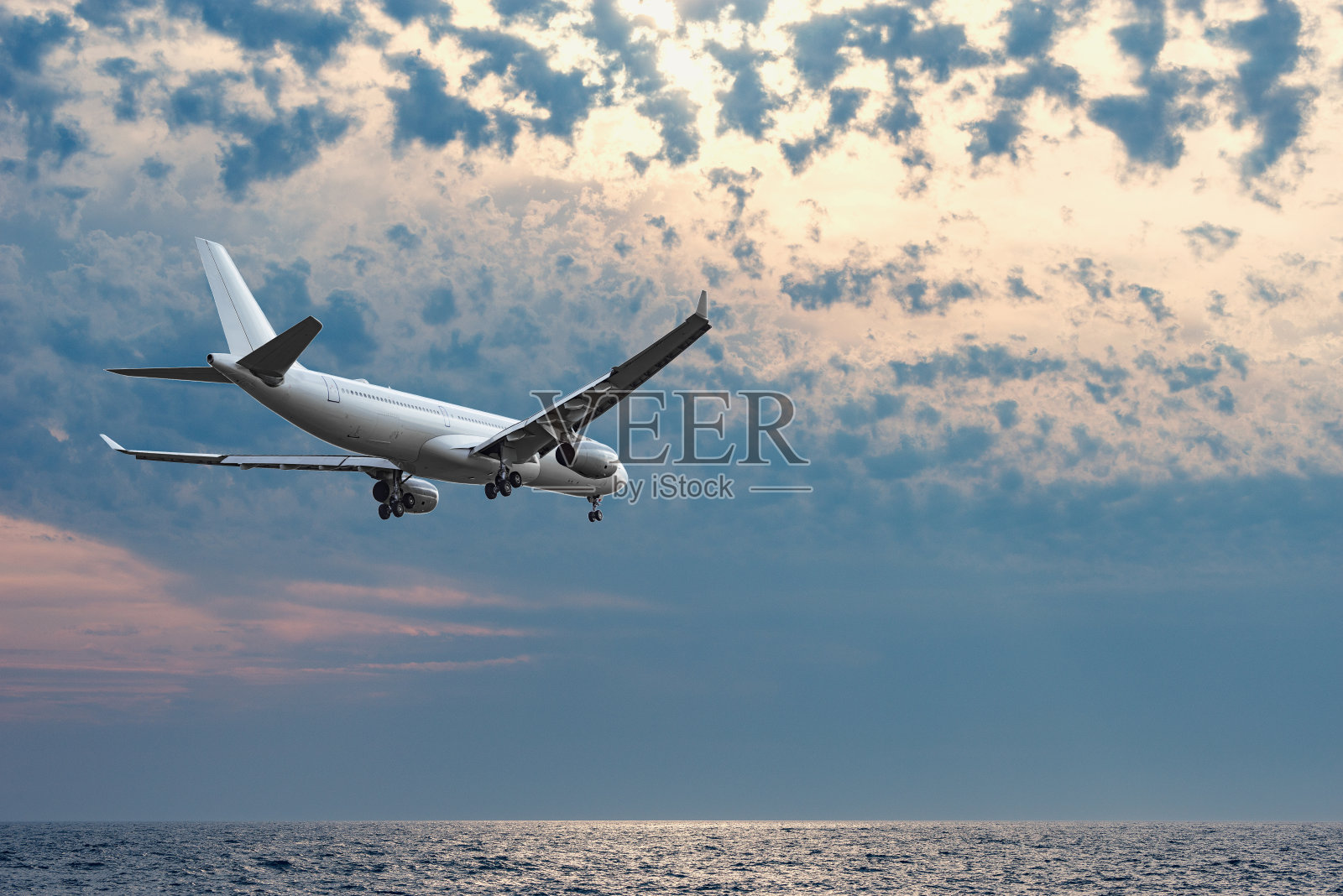 在着陆前在海面上飞行的飞机。照片摄影图片