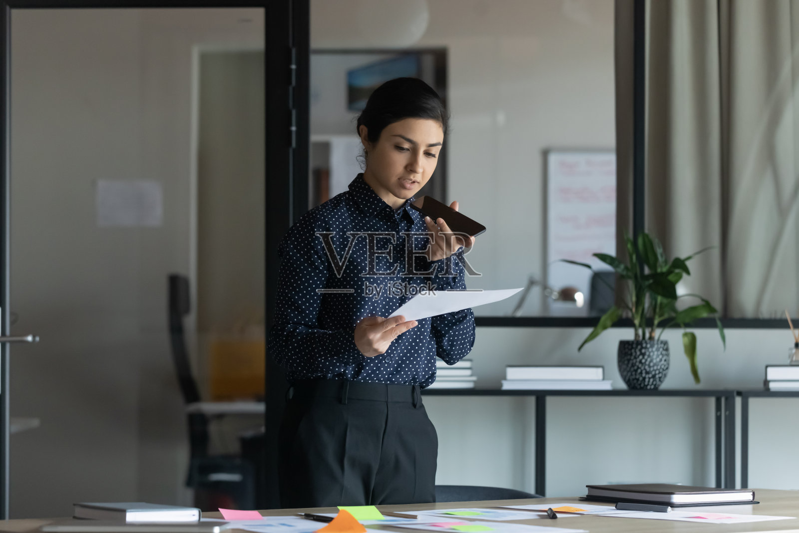 女商人在读信,讨论工作问题,通过电话扬声器交谈照片摄影图片