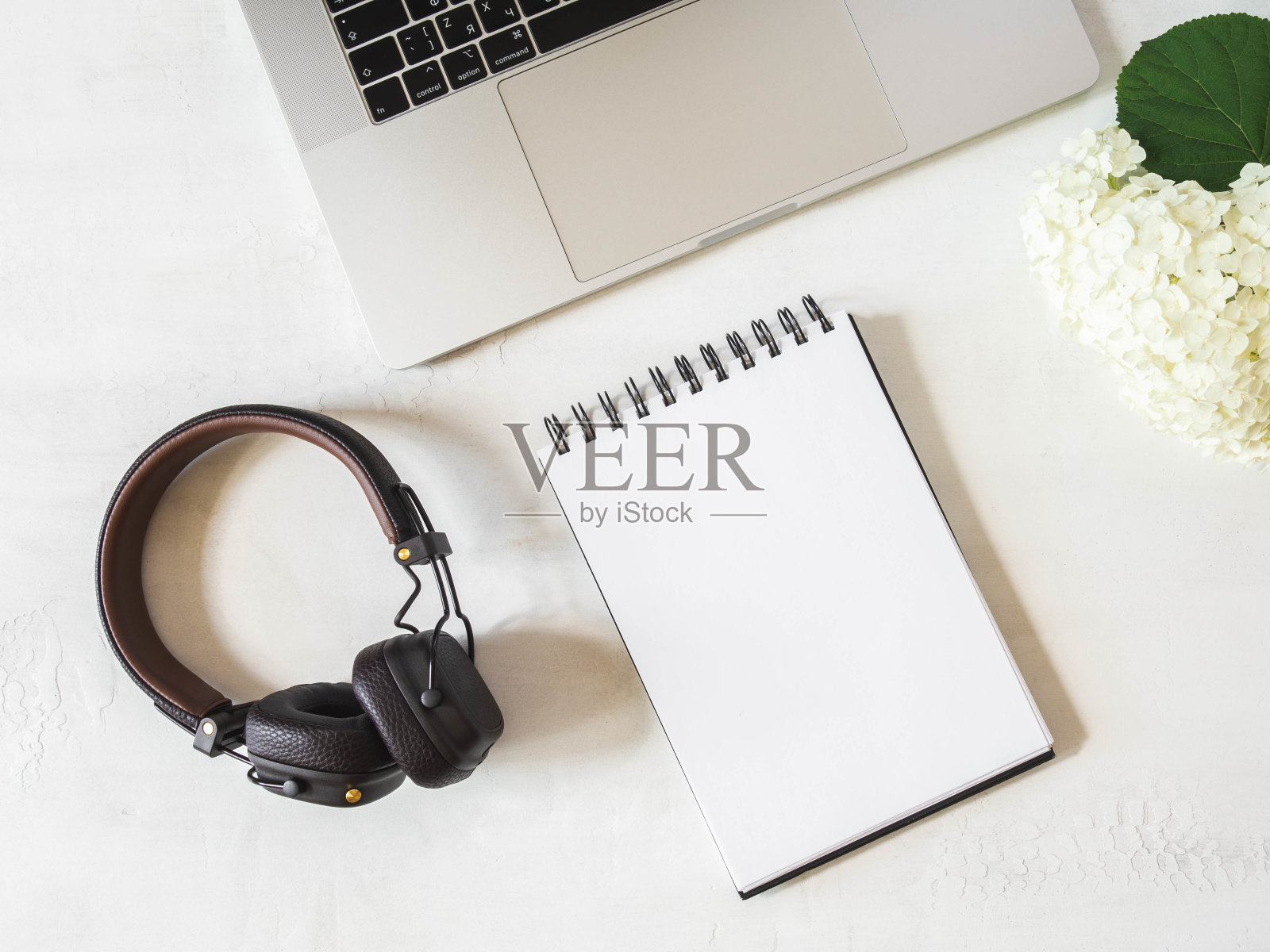 家庭办公室办公桌工作与笔记本电脑,剪贴板与白纸文本,铅笔,白色绣球花和耳机在白色背景。平躺,俯视图女孩工作经营理念。照片摄影图片