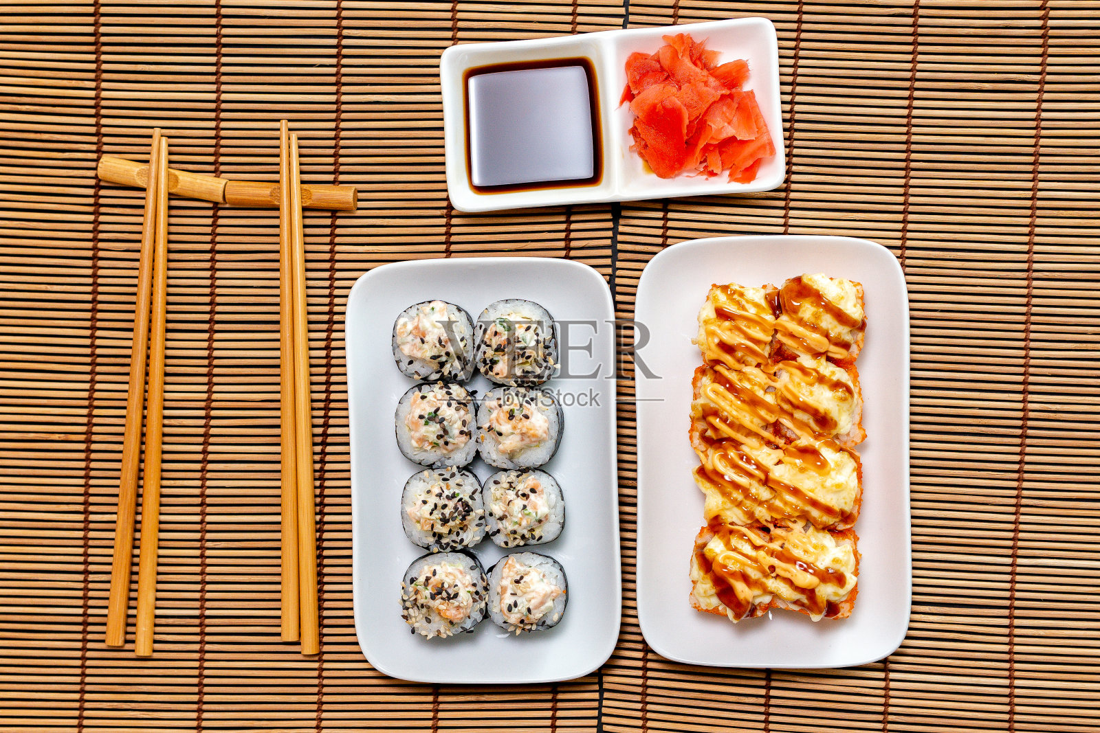 寿司卷在盘子里。设置为两人用筷子,生姜,酱油,俯视图,拷贝空间照片摄影图片