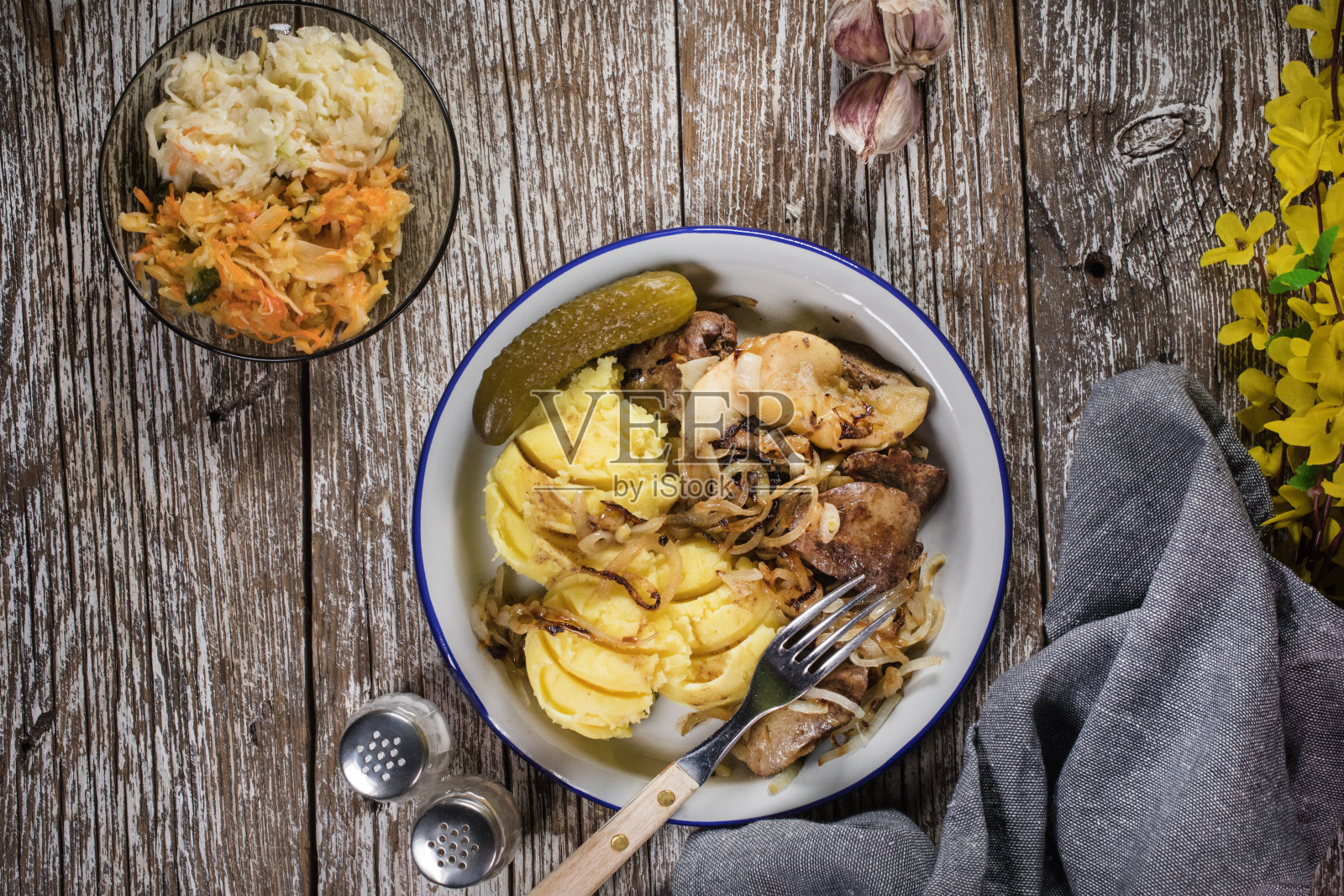 洋葱苹果炒肝,配煮土豆和腌黄瓜。照片摄影图片