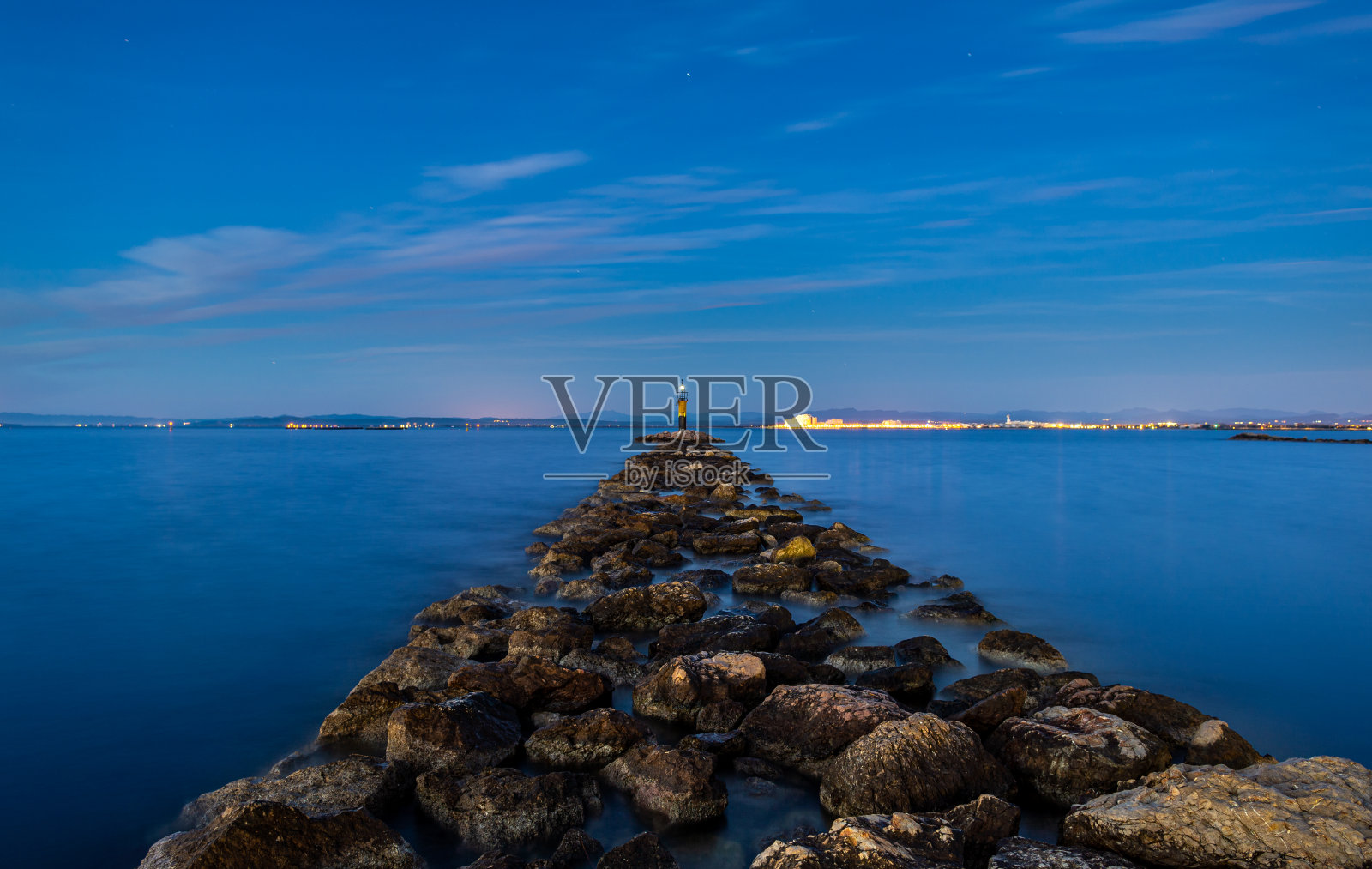 防波堤岩石在玫瑰湾,西班牙,科斯塔布拉瓦,在长时间暴露照片摄影图片