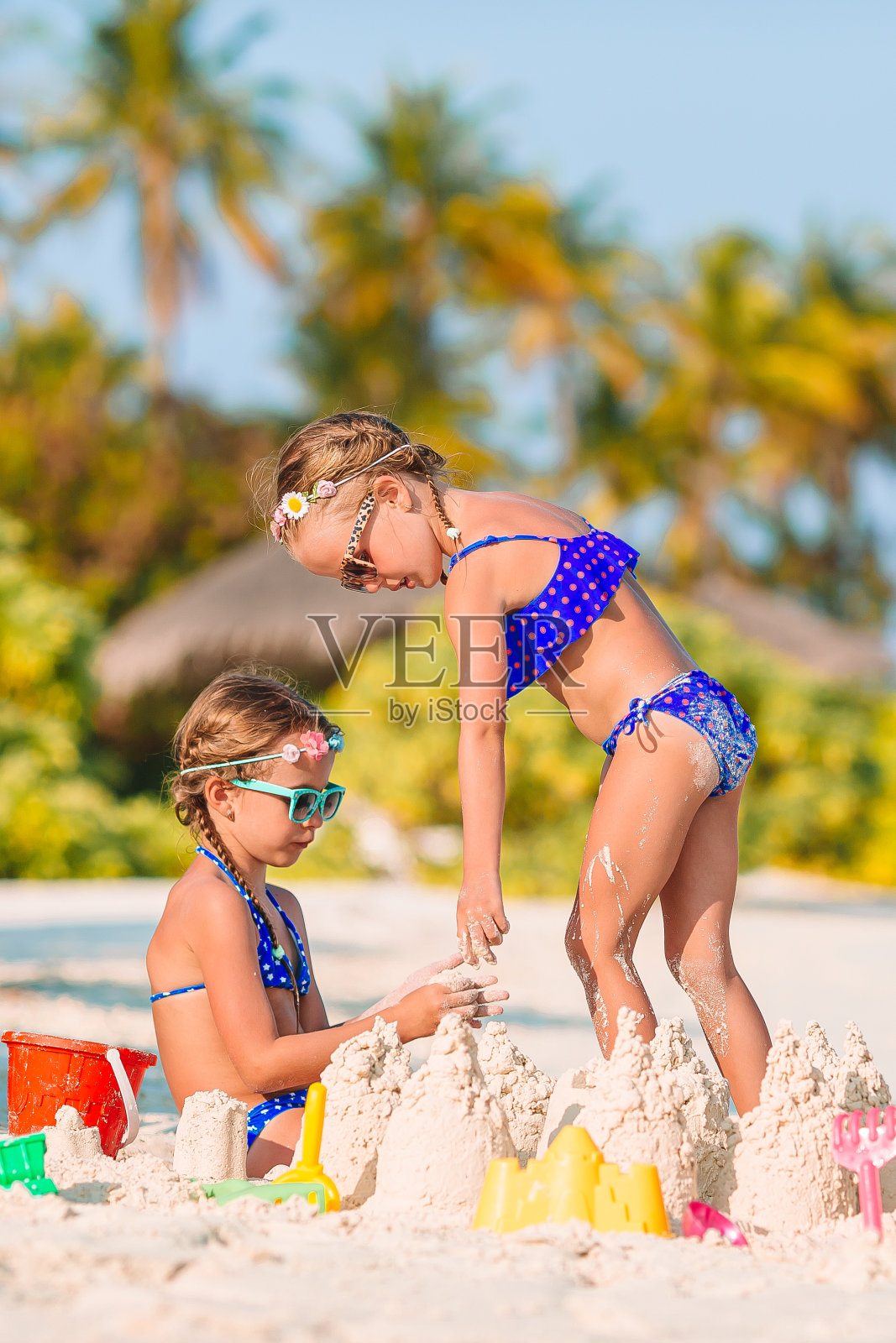 两个孩子在做沙堡,在热带海滩玩得很开心照片摄影图片