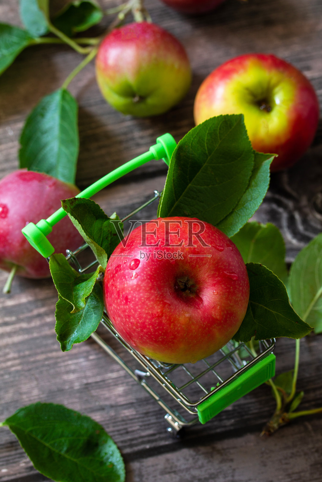 成熟的红苹果在购物车上木制的背景。照片摄影图片