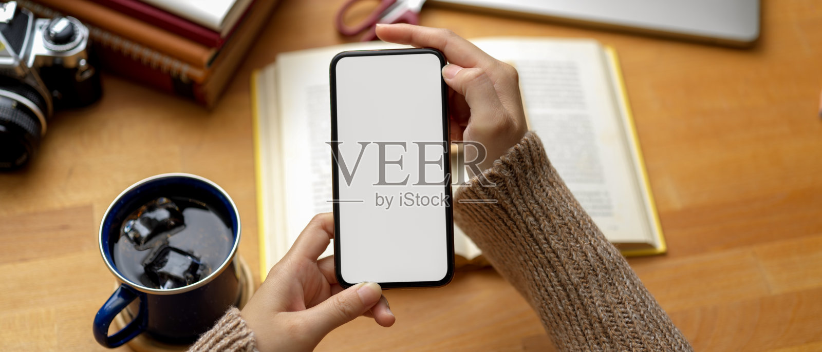 女学生在课桌上使用模拟智能手机和书籍和咖啡杯照片摄影图片