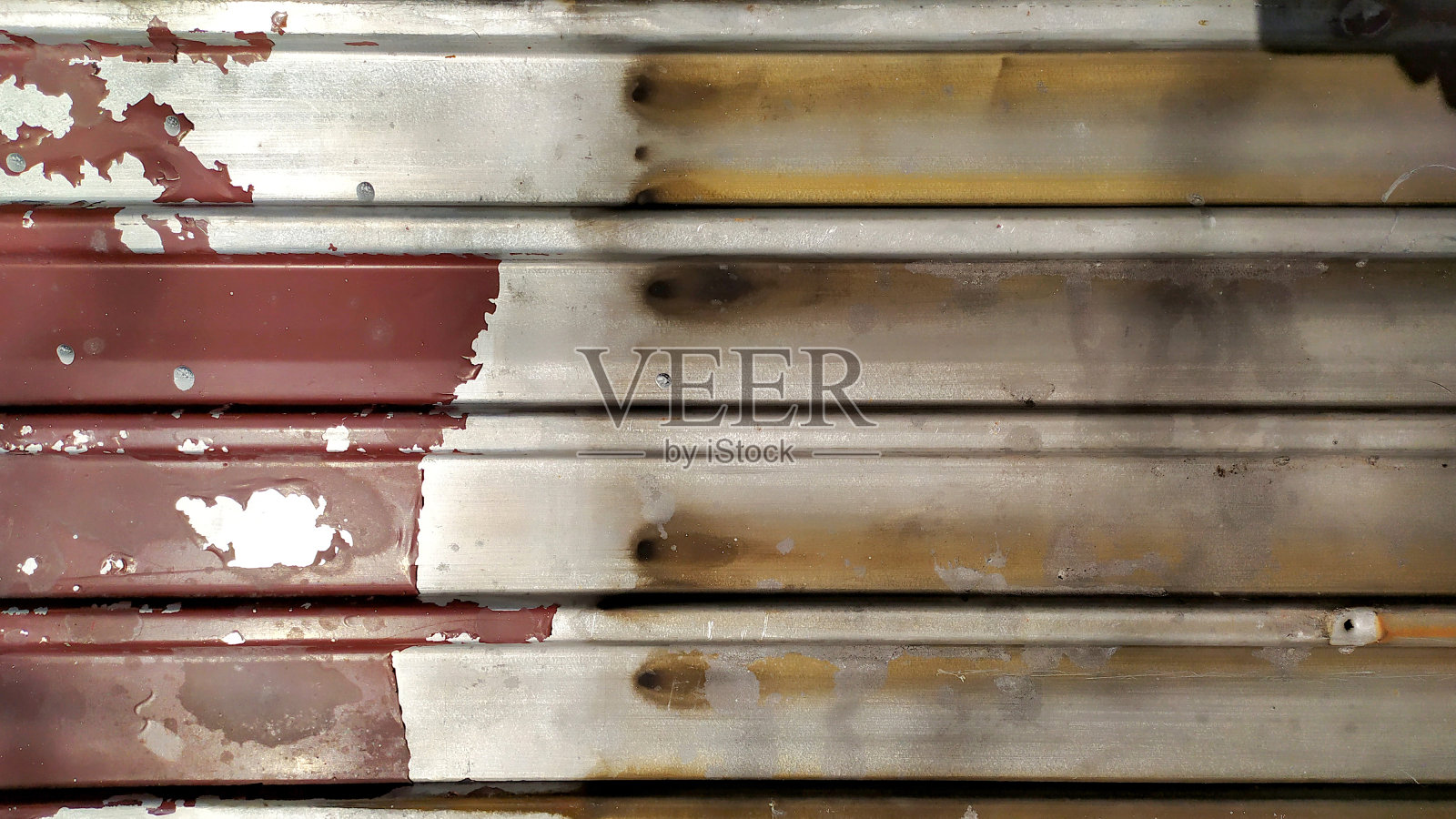 剥落的红漆。不干净的金属板。照片摄影图片