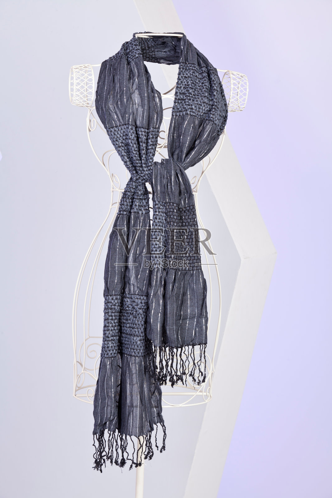 人体模型上的灰色镶边围巾。照片摄影图片