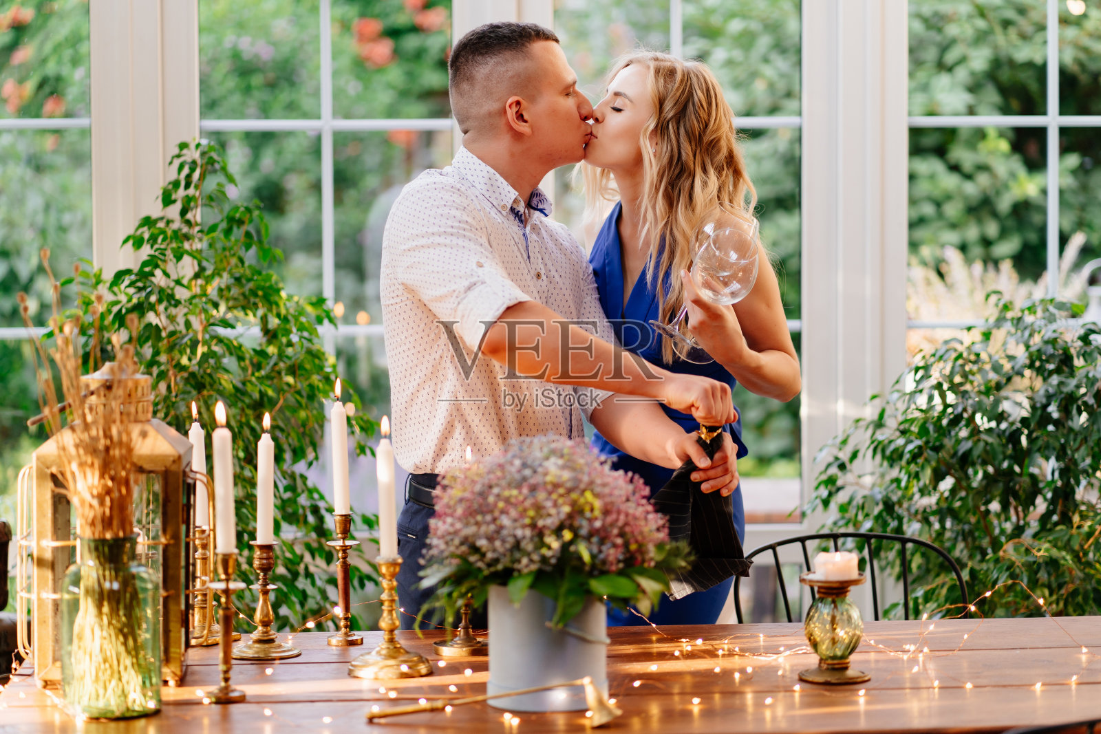 爱幸福的情侣在浪漫的晚餐与玻璃。人倒香槟。照片摄影图片