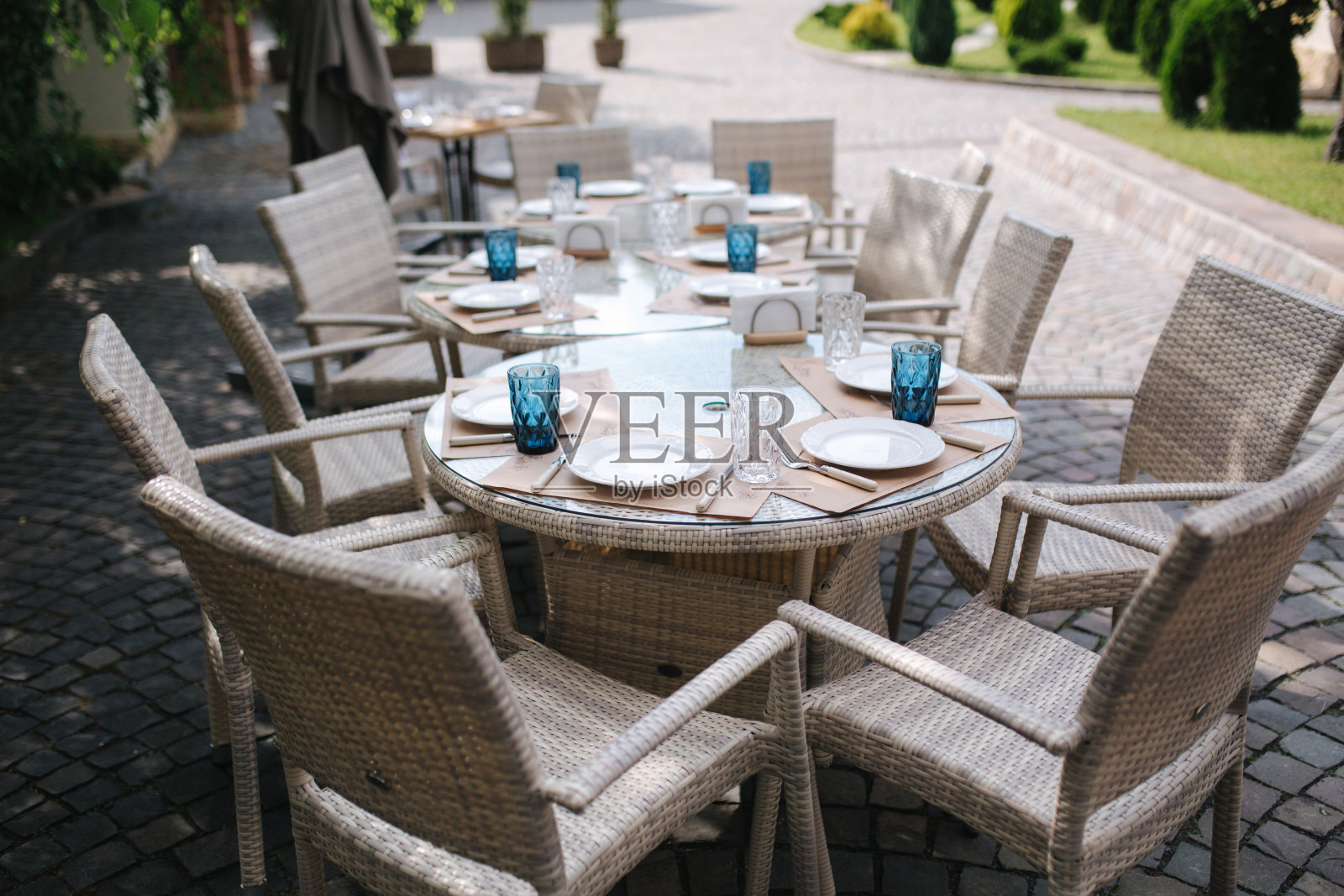 餐桌在夏季露台设置。餐具在咖啡馆。绿色背景照片摄影图片