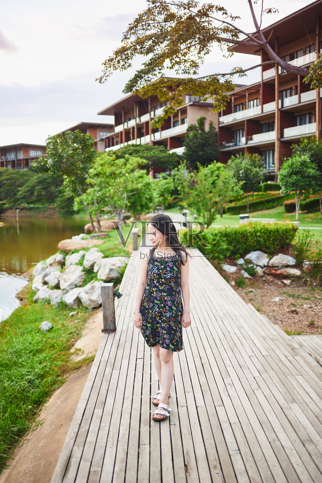 亚洲女孩晚上在花园的木桥上散步照片摄影图片