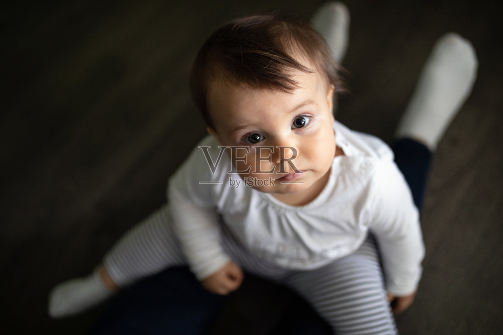 可爱的女婴在妈妈的腿上照片摄影图片