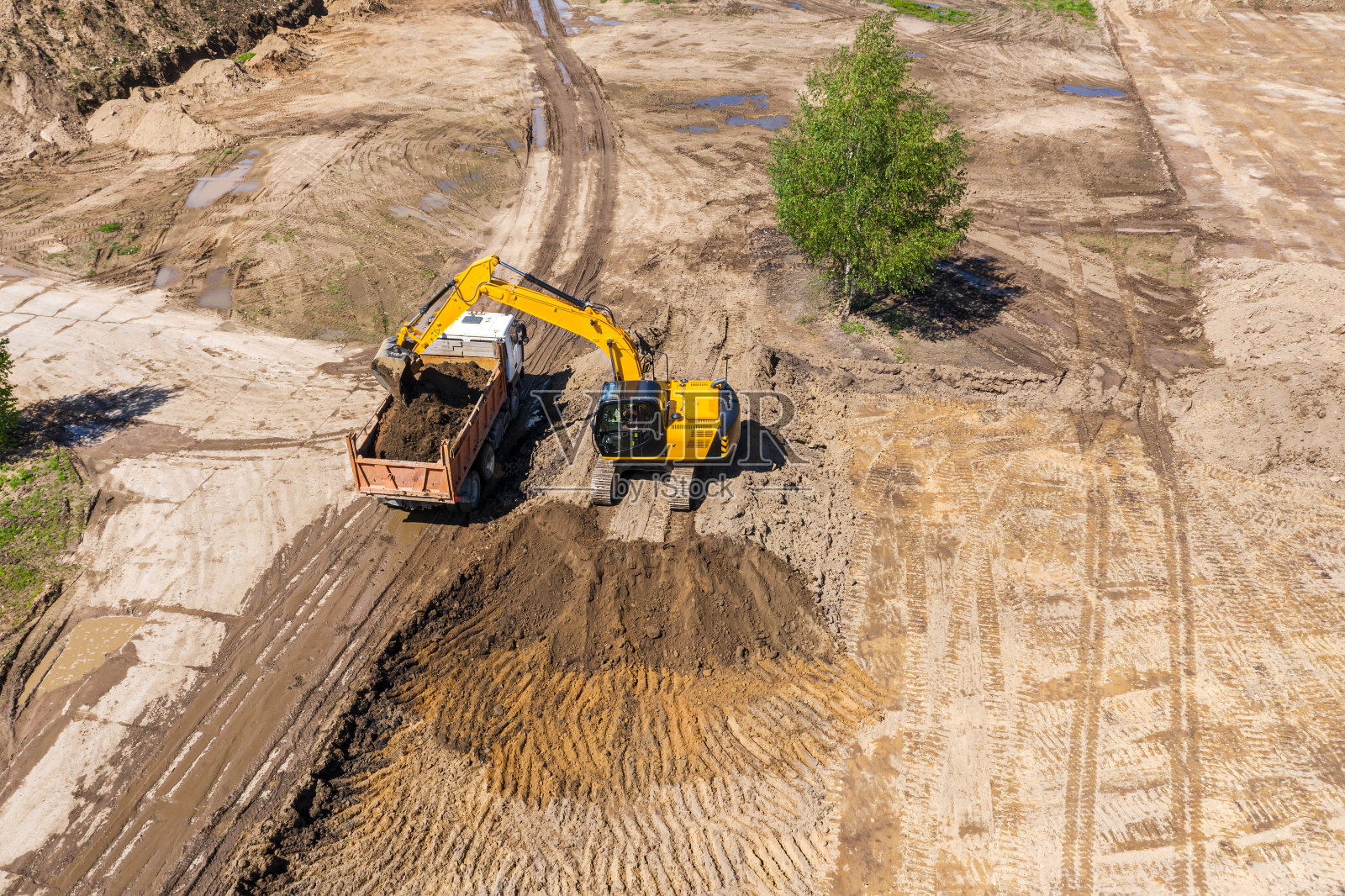 在建筑工地工作的挖土机和自卸车。航拍照片照片摄影图片