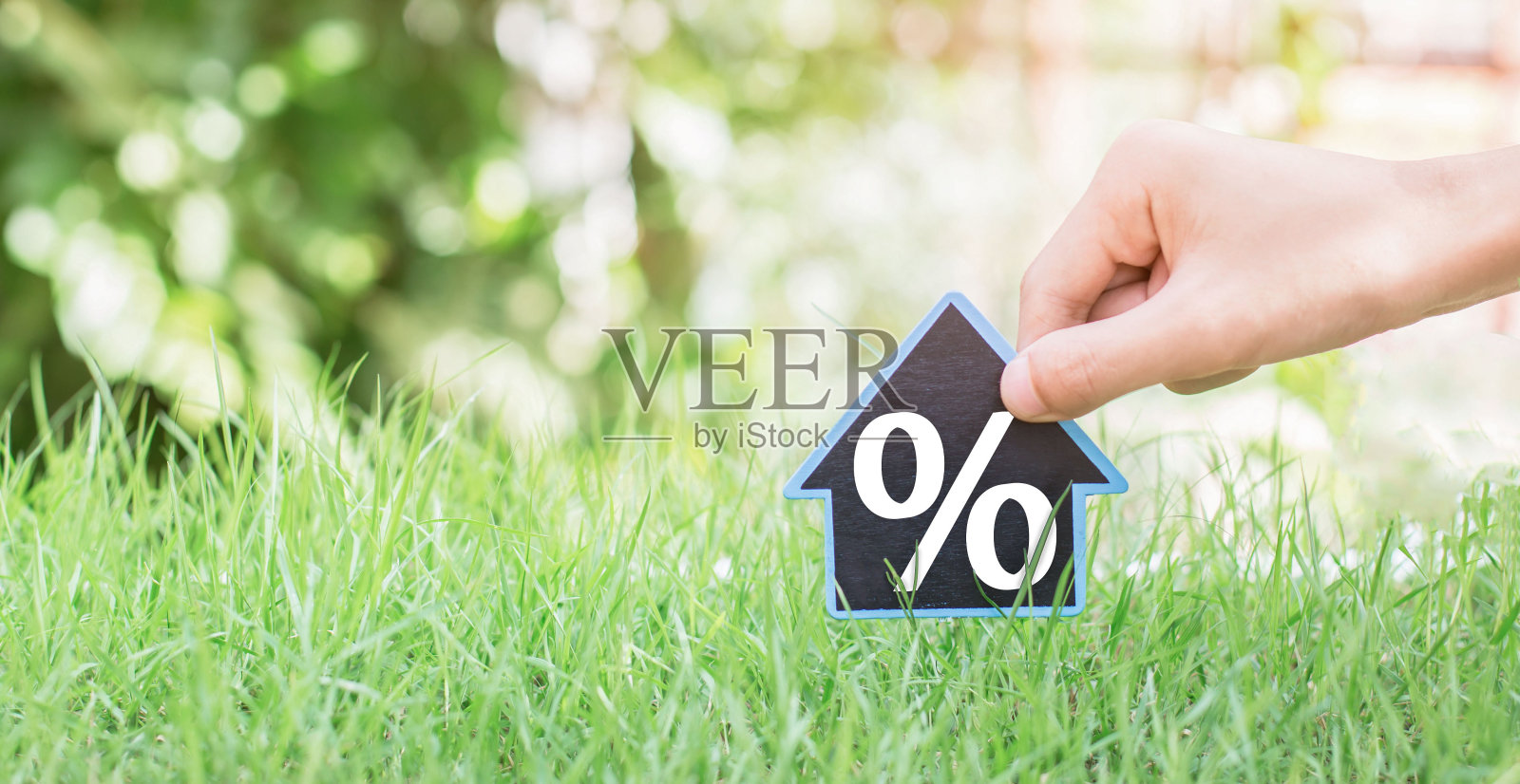 人们把房子的标志与兴趣符号与地方大头针和绿色的草。带利息买房子的概念。照片摄影图片