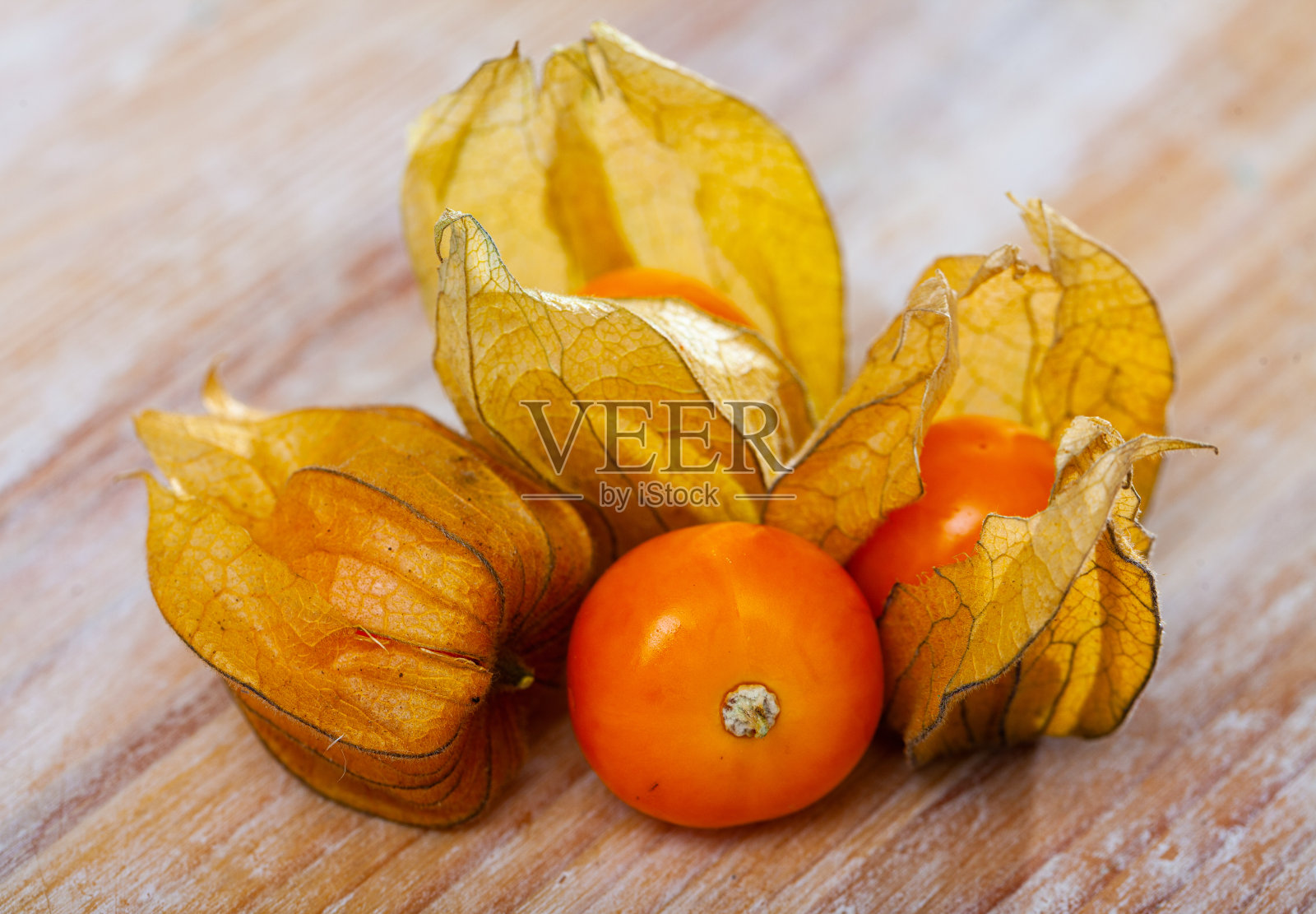 木桌上放着橘子酸浆照片摄影图片