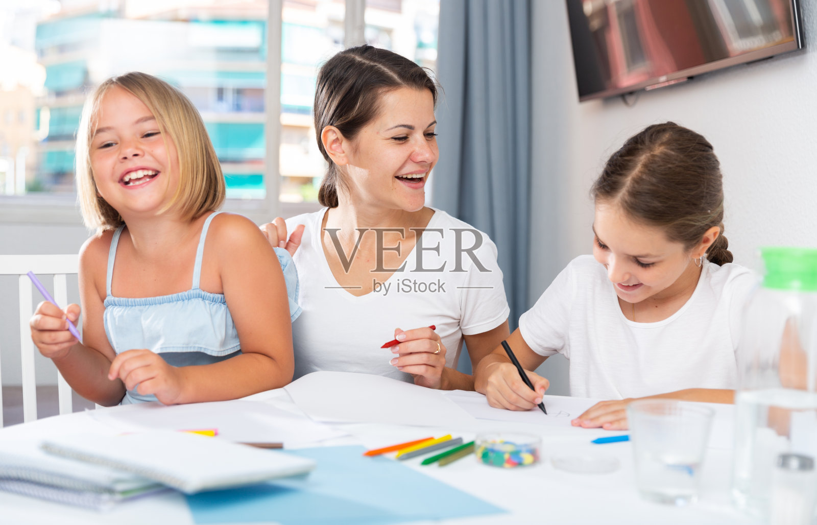 母亲和两个孩子一起用蜡笔照片摄影图片