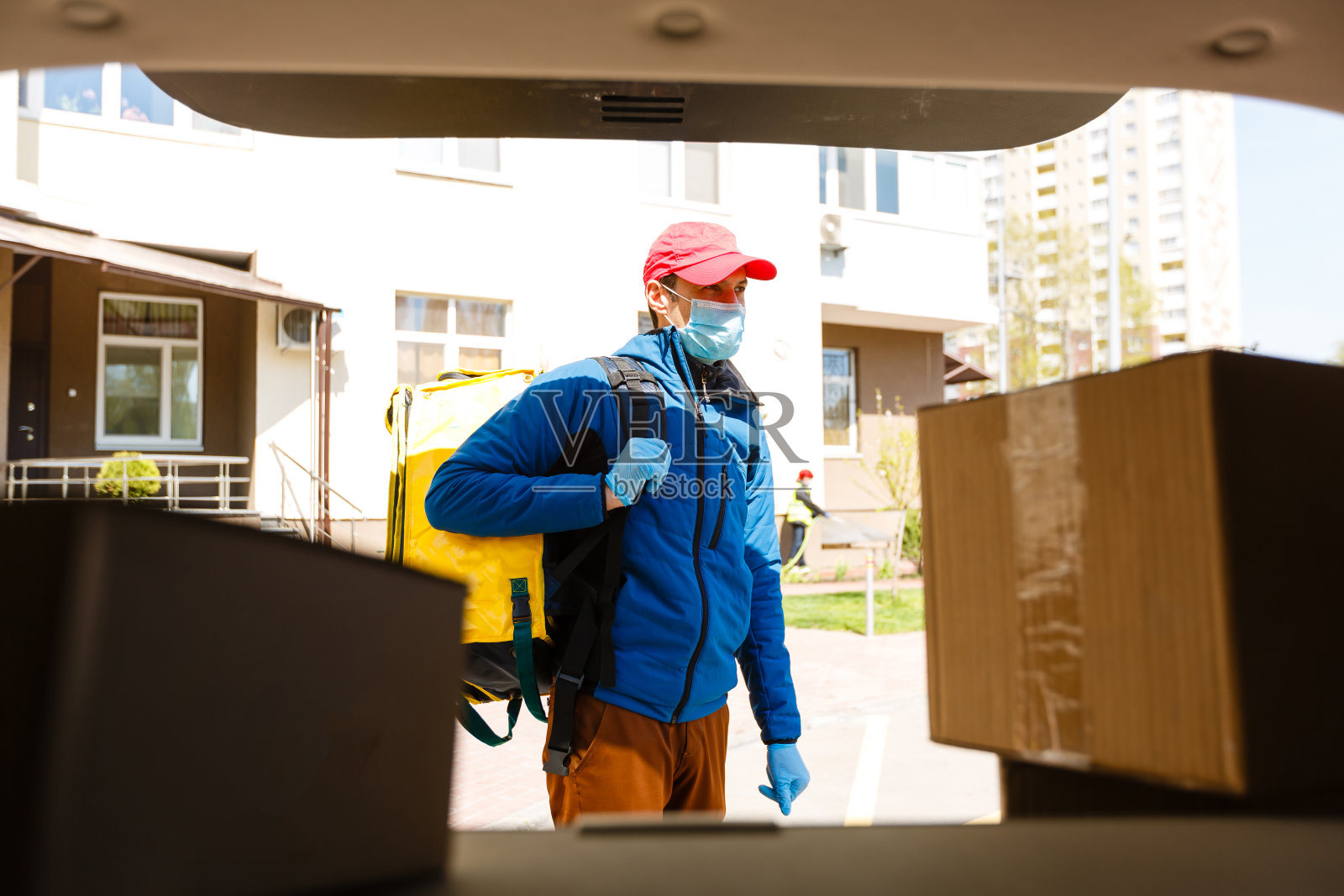非接触式食品送货上门。带保温背包的快递员从餐厅、超市或咖啡馆快速送出被隔离的食物。在线订购食物照片摄影图片