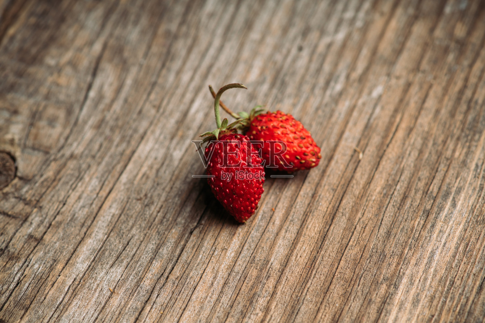 新鲜收获的野草莓在乡村木质背景上照片摄影图片