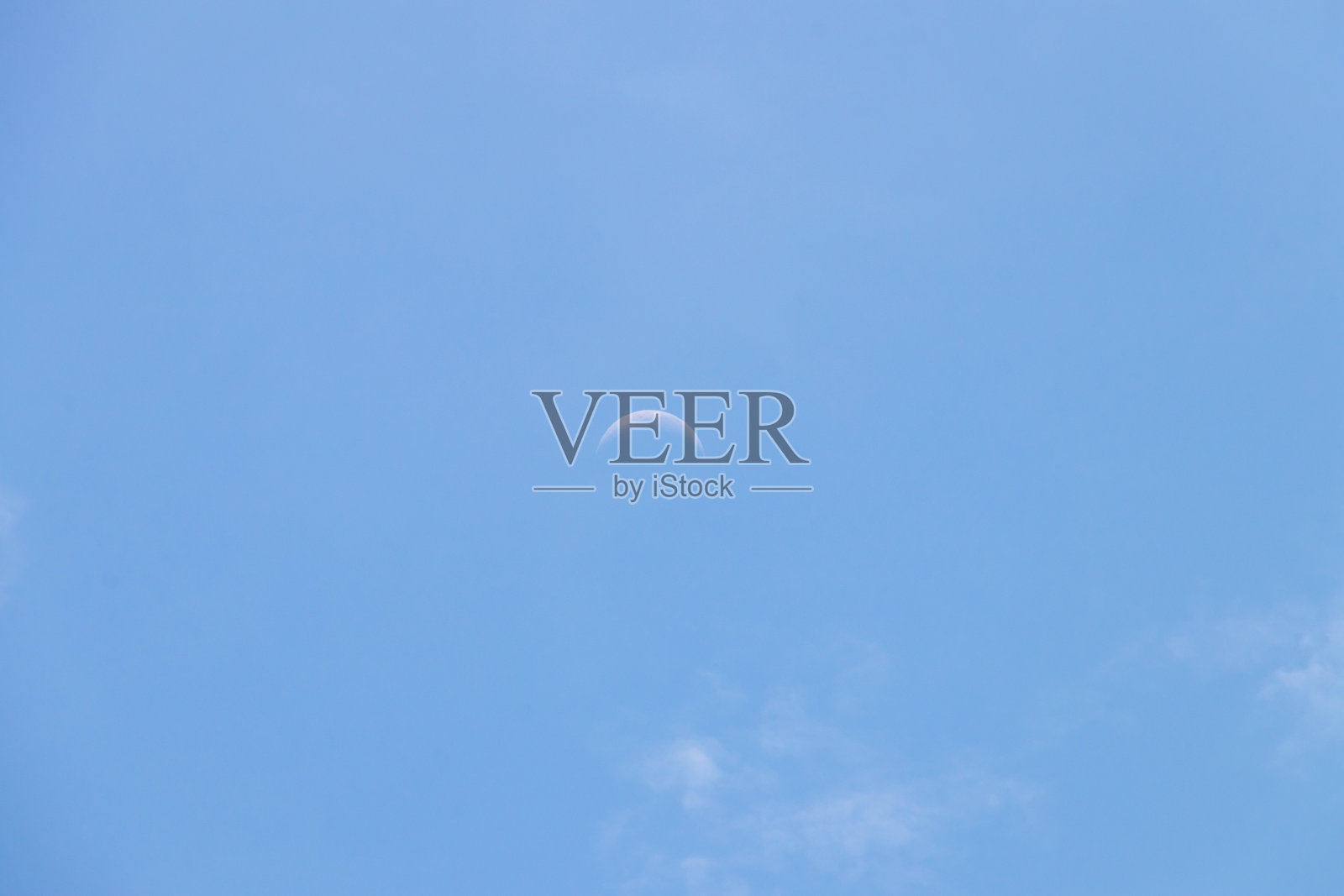 蓝天上的新月。看起来像在美好的日子里微笑。照片摄影图片