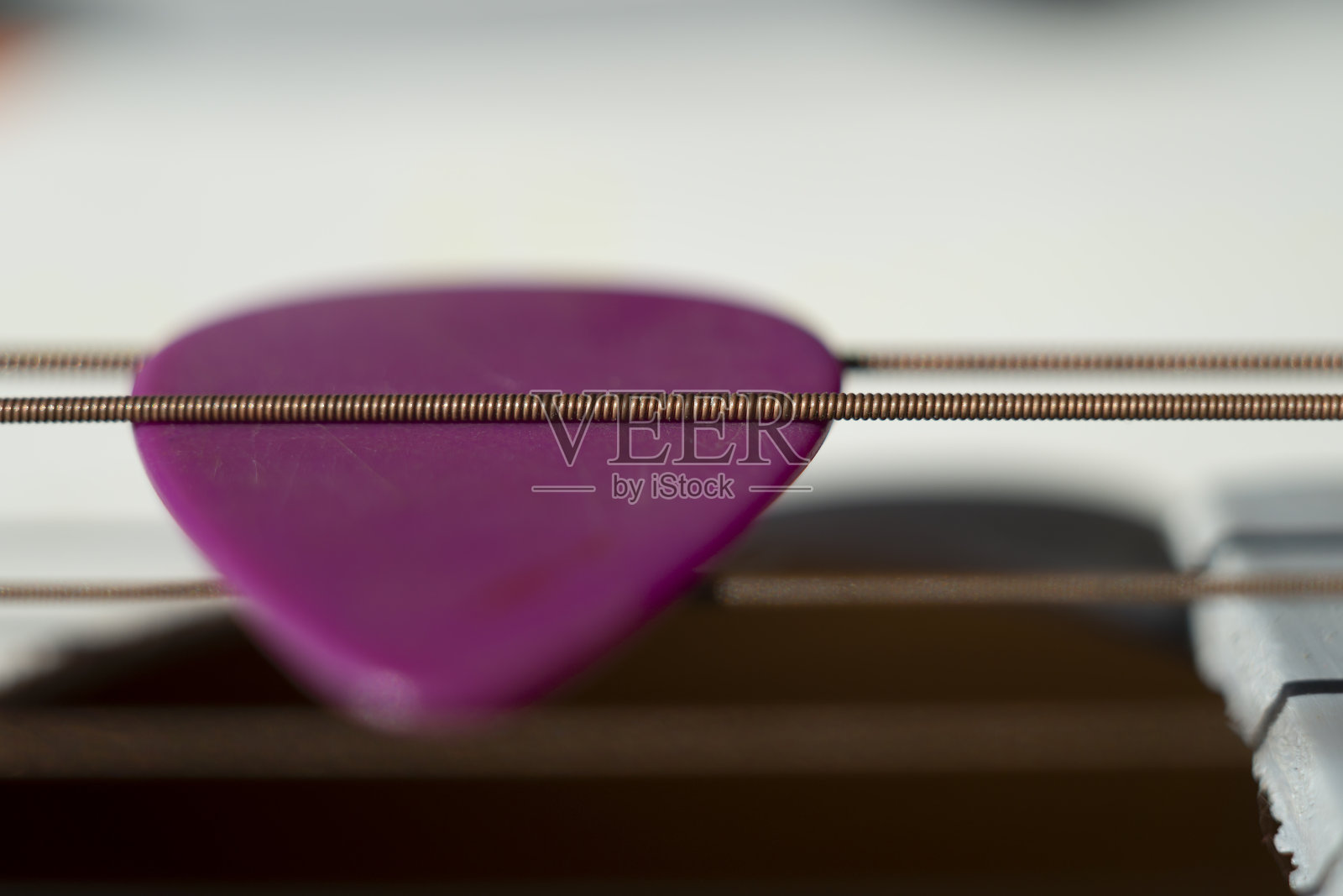 彩色的粉红色拨子在吉他弦照片摄影图片