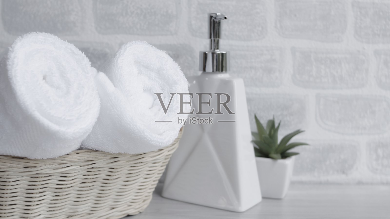 漂亮的白色毛巾折叠在房间里的白色桌子上照片摄影图片