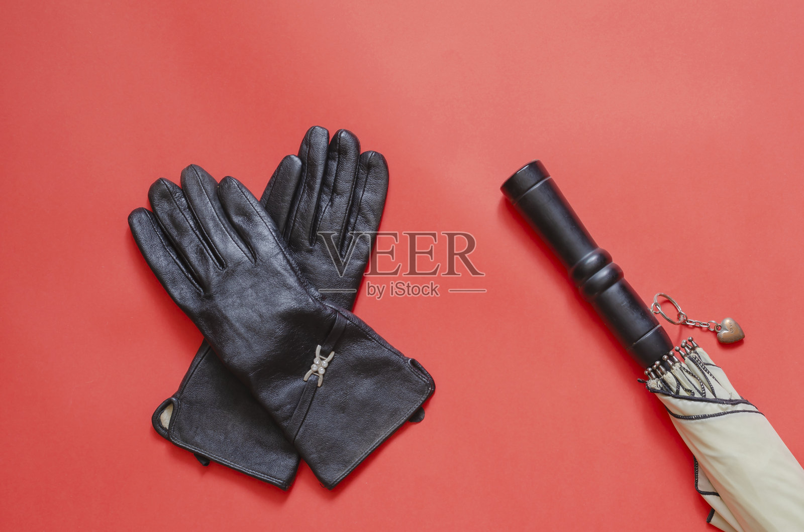 女性皮手套和伞上的珊瑚背景。照片摄影图片
