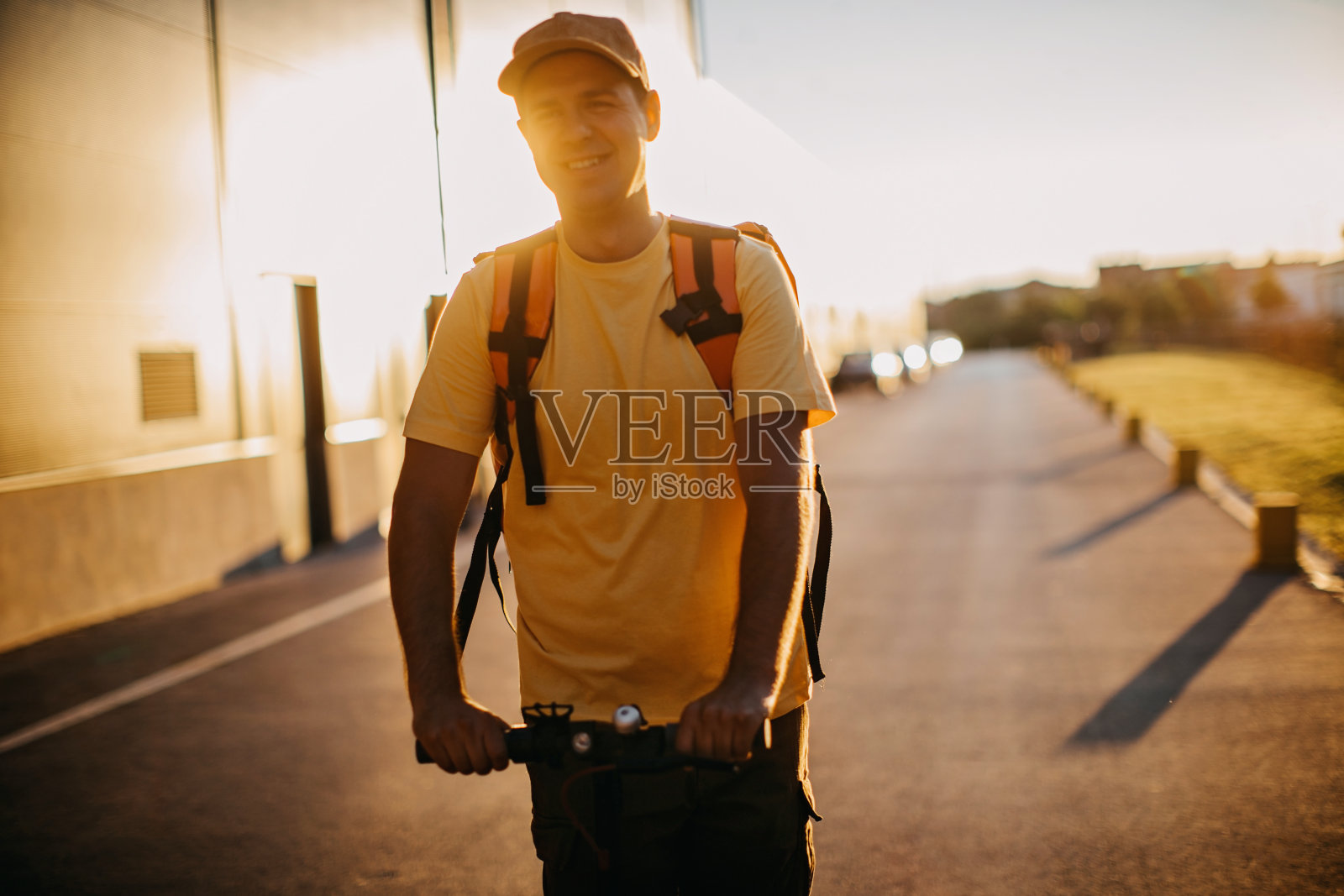 年轻的送货员骑着电动车送包裹照片摄影图片