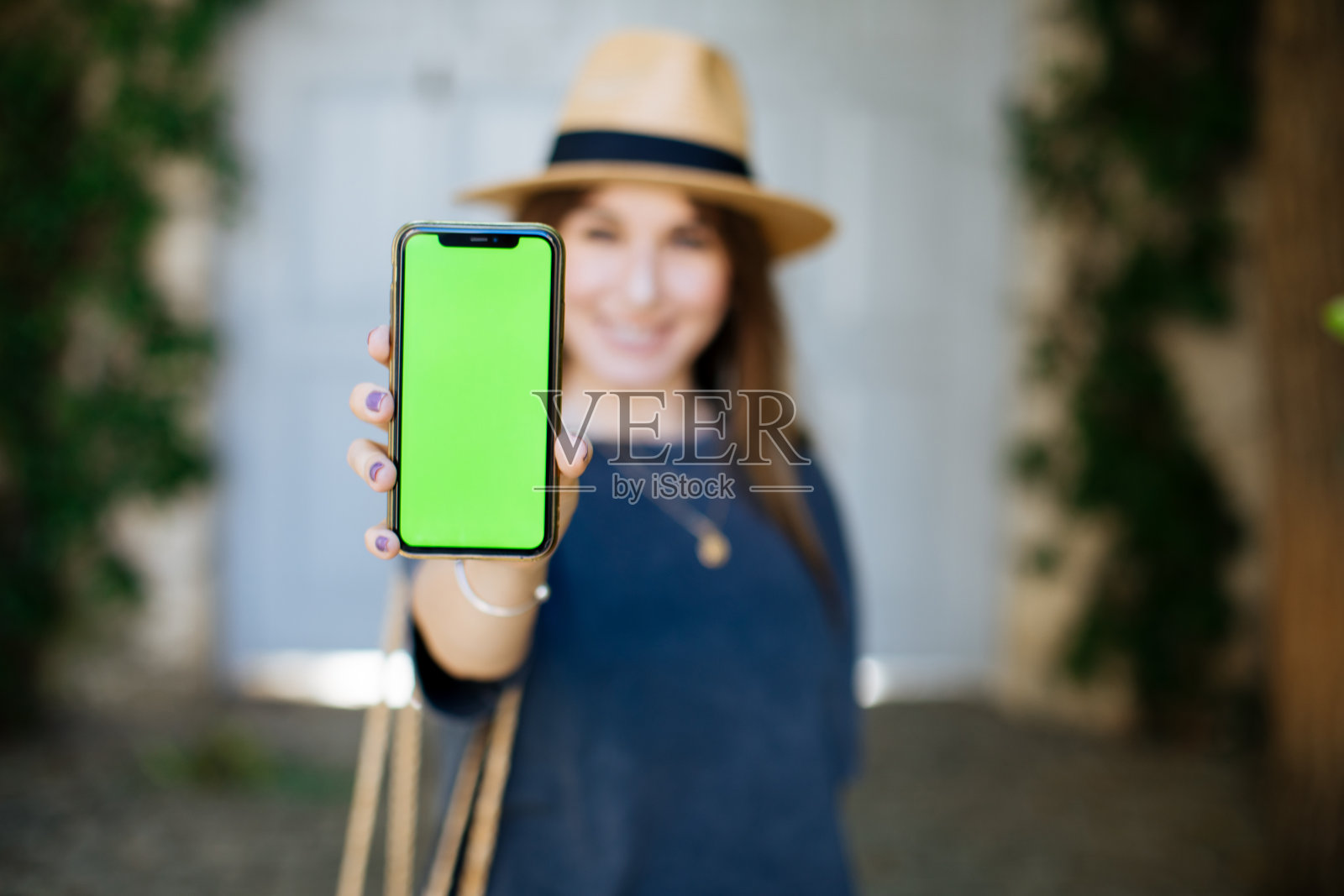 智能女人的手握和触摸手机智能手机与色度键绿色屏幕在城市背景照片摄影图片