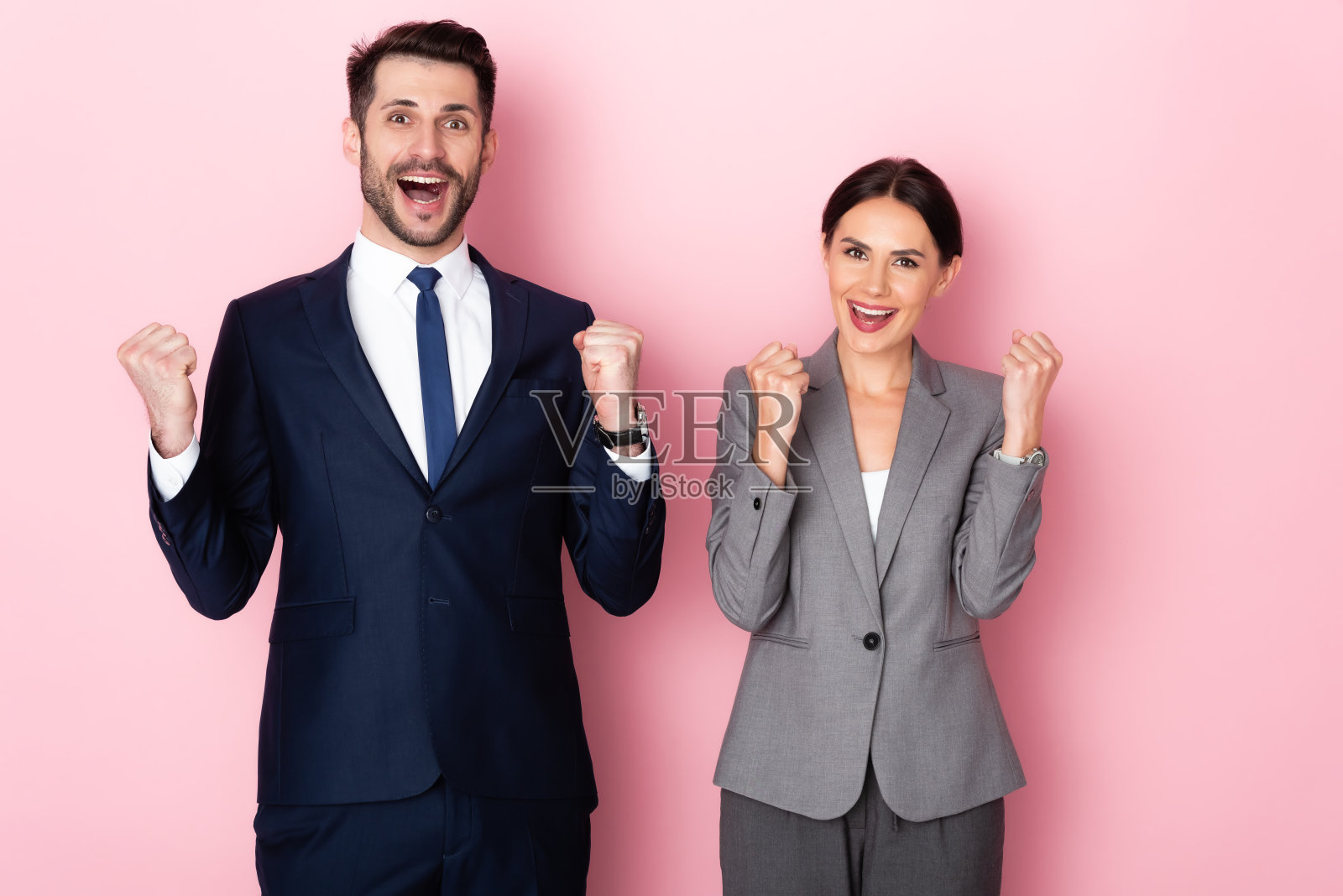 兴奋的商人和女商人庆祝胜利的粉红色,性别平等的概念照片摄影图片