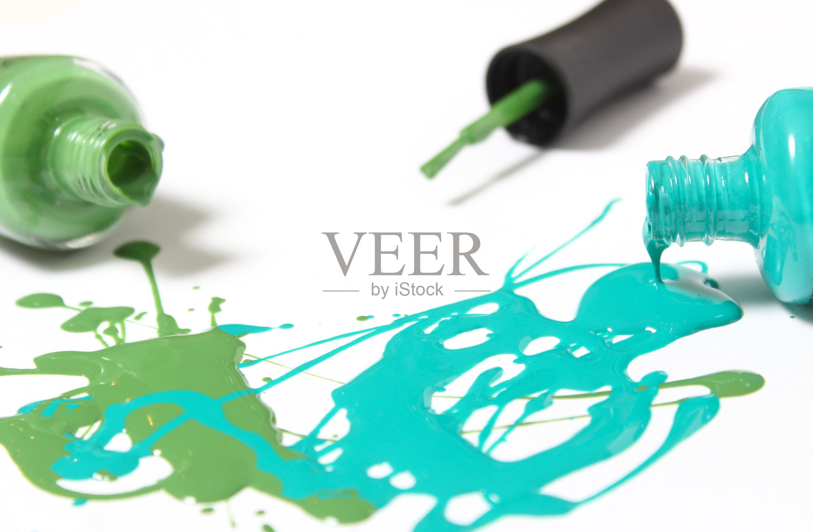 蓝色和绿色的指甲油洒在白色的指甲油上照片摄影图片