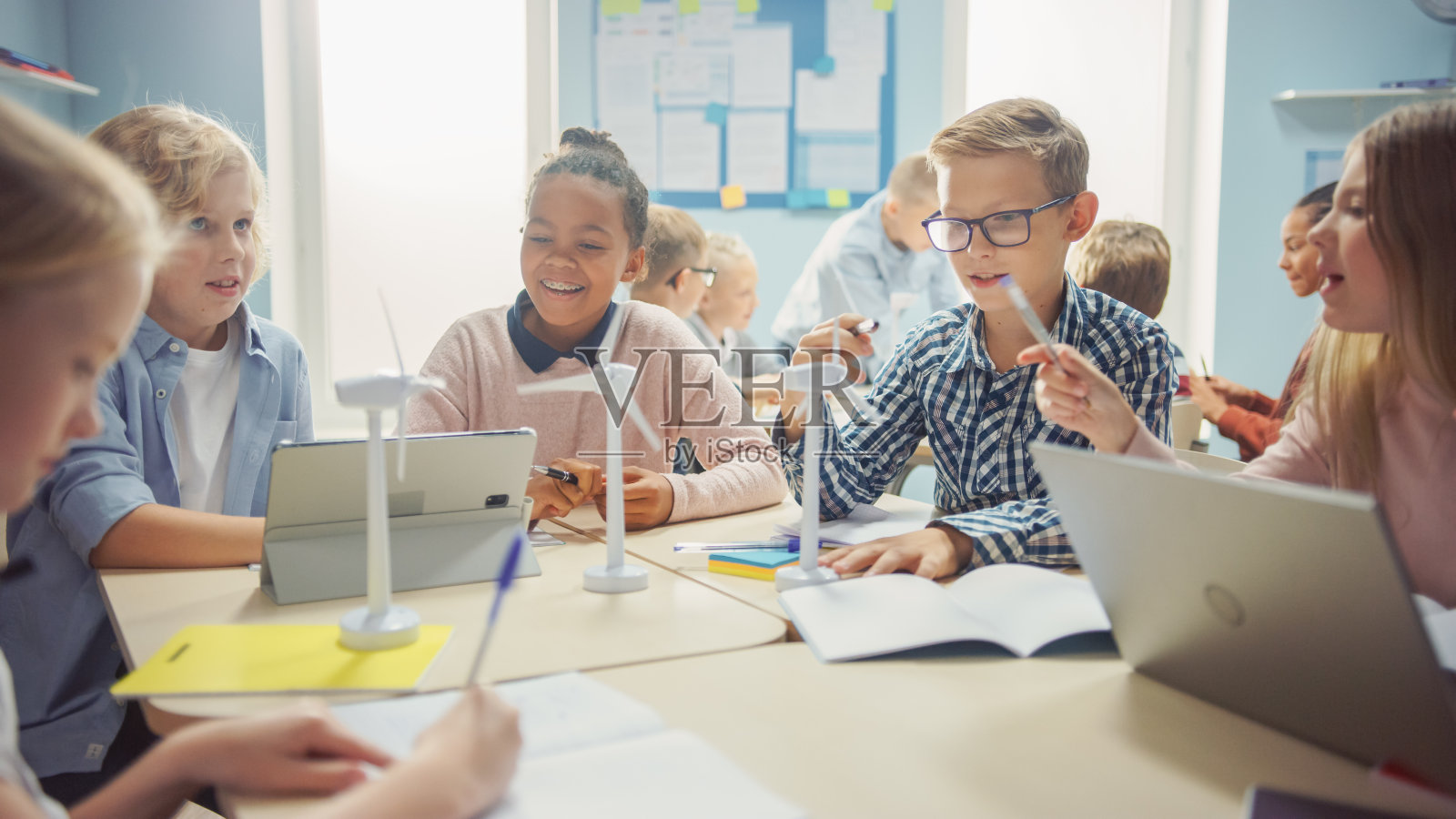 在小学:聪明的孩子们作为一个团队使用平板电脑编程风力涡轮机。与孩子们一起学习环保形式的可再生能源照片摄影图片