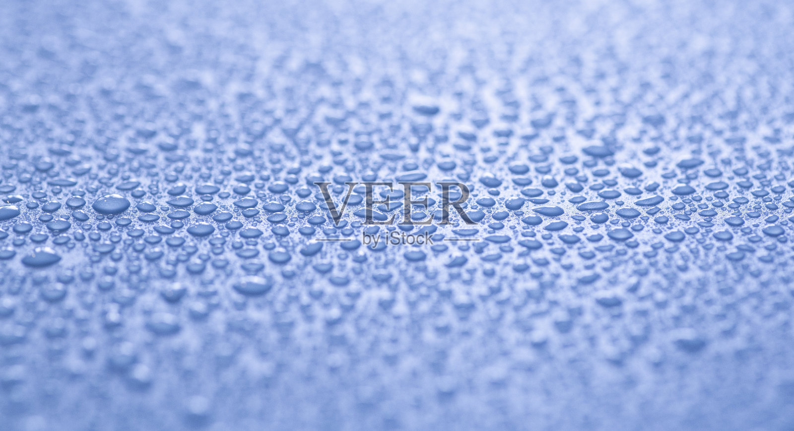 水滴落在彩色的背景上。雨滴,蒸汽或凝结。水滴的背景接近照片摄影图片