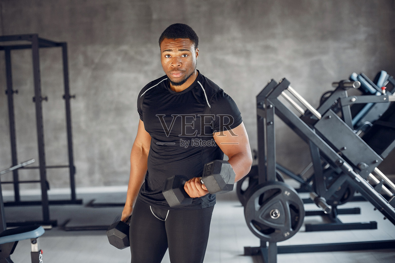 一个英俊的黑人正在健身房里工作照片摄影图片