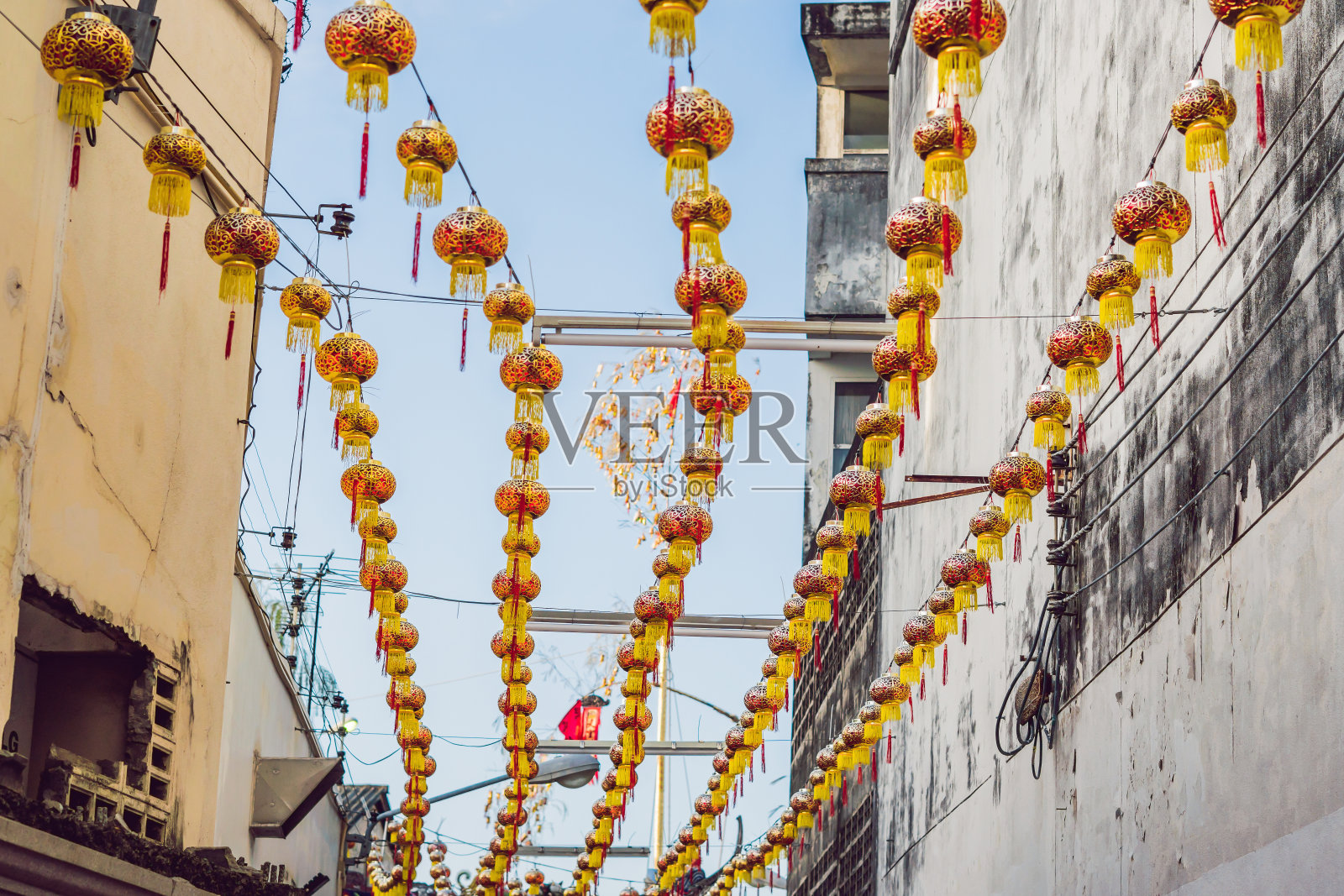 红色的中国灯笼在白天挂在房子之间照片摄影图片