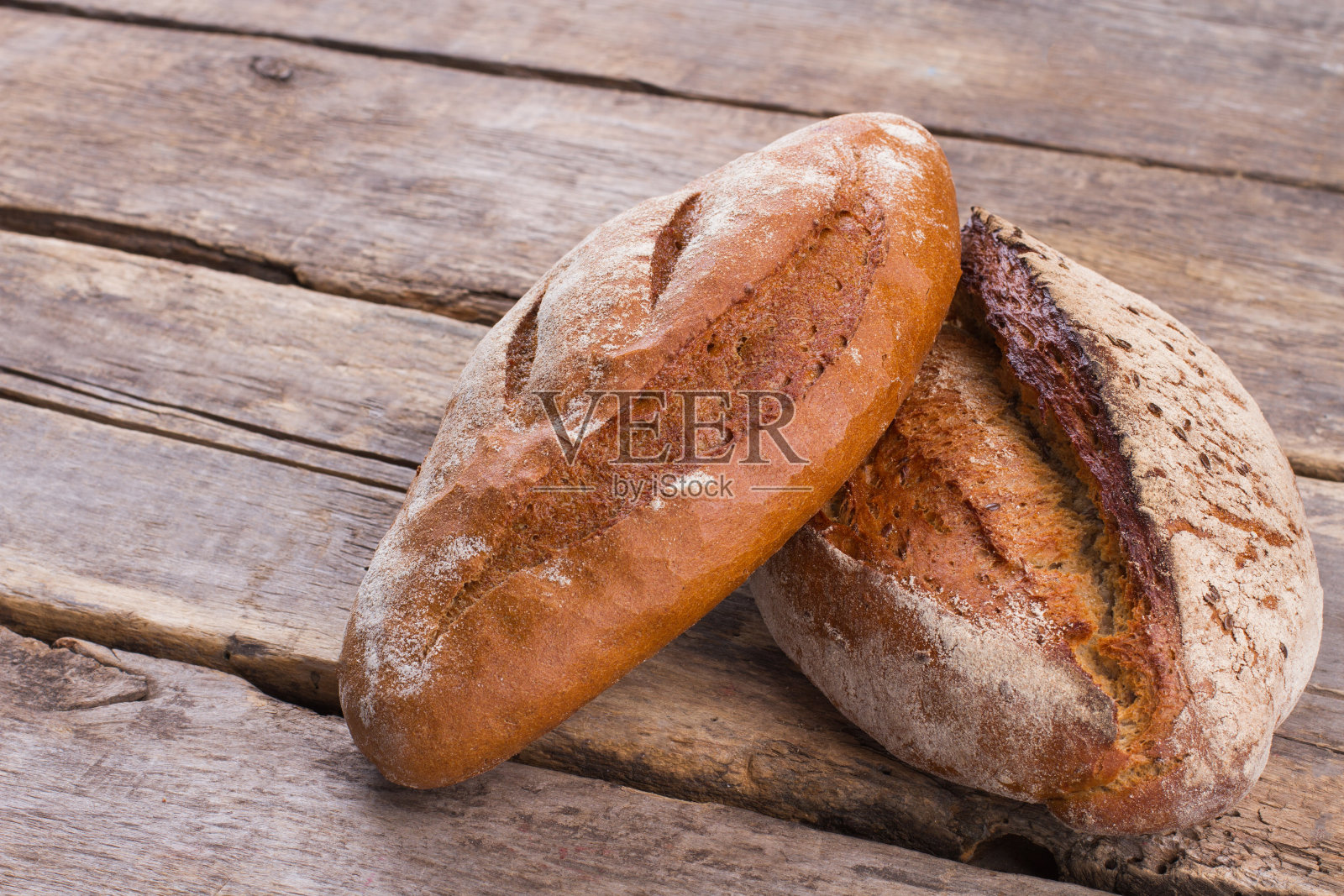 木制背景上的传统小麦面包。照片摄影图片