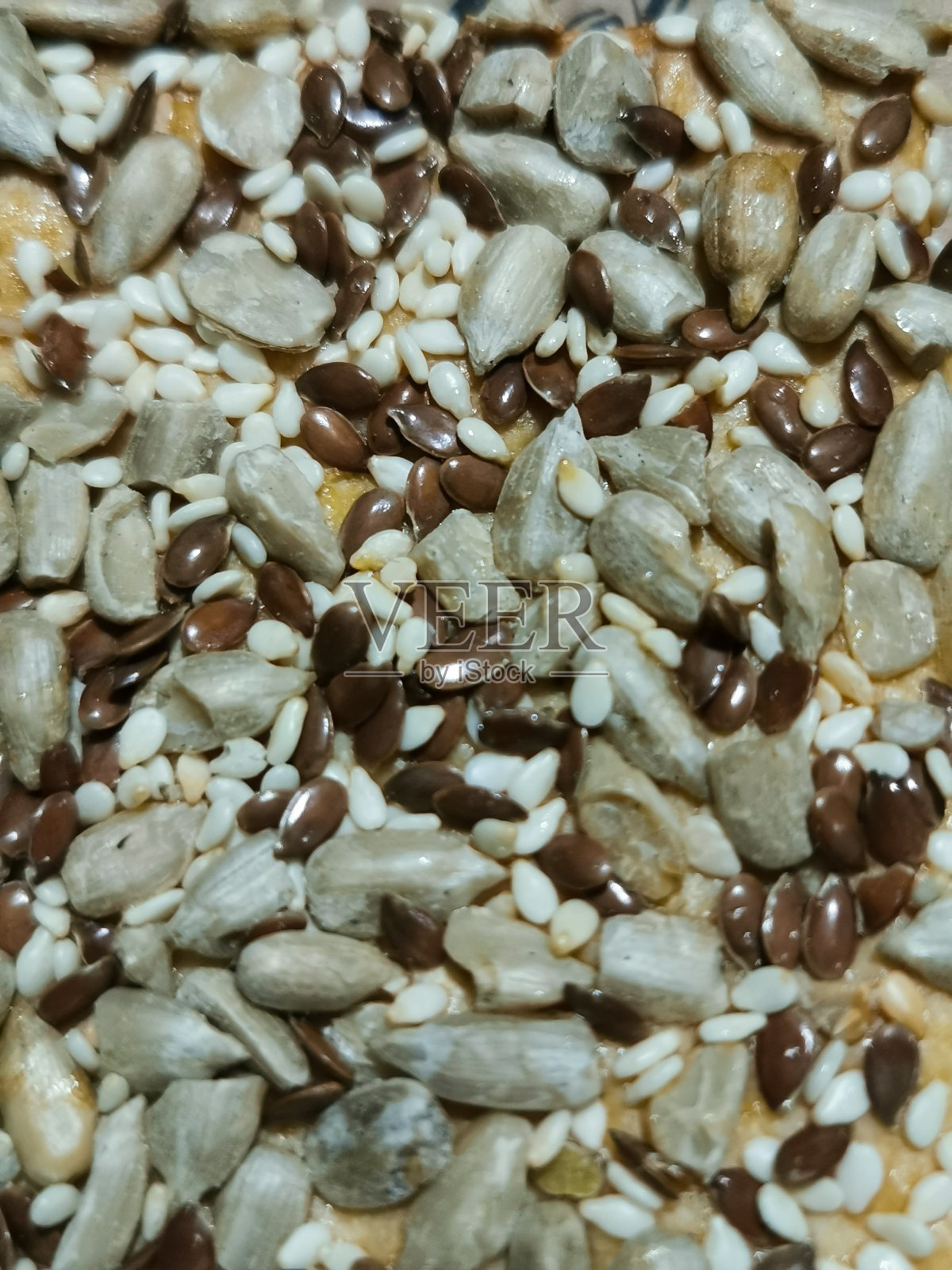 健康的生活方式的概念。背景是葵花籽,亚麻和芝麻的纹理。照片摄影图片