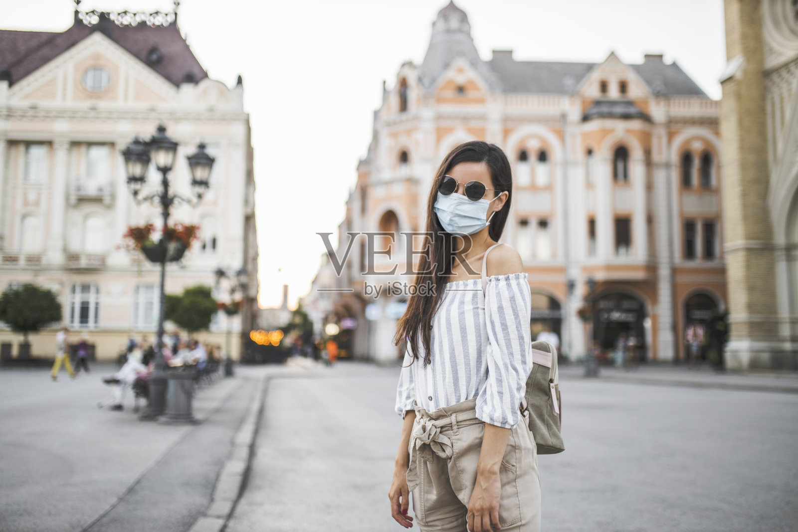 为预防冠状病毒和防雾霾,年轻妇女戴着口罩上街的肖像照片摄影图片