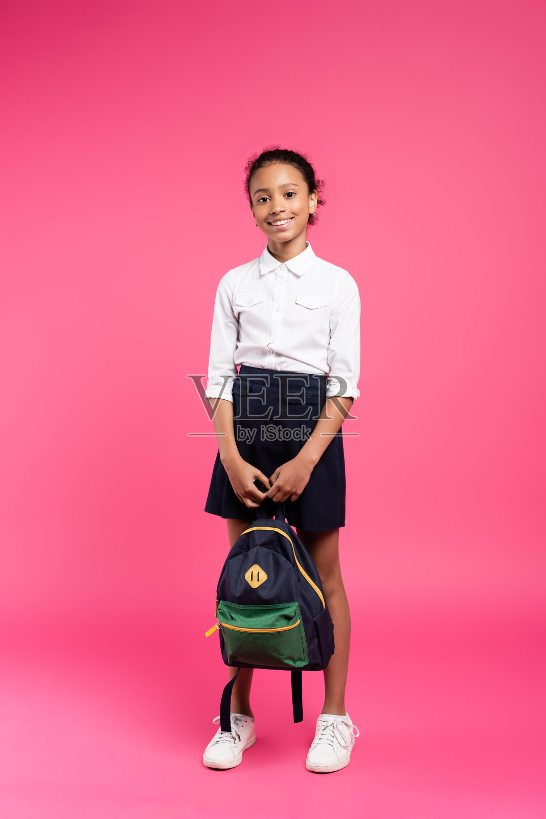 全长度的笑容非洲裔美国女学生与背包在粉红色的背景照片摄影图片