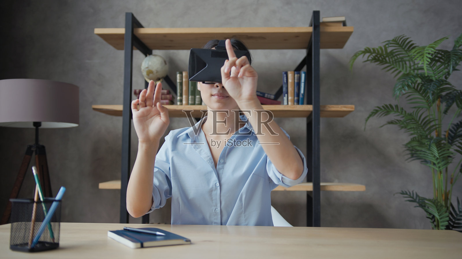 年轻漂亮的亚洲学生戴着虚拟现实眼镜工作照片摄影图片