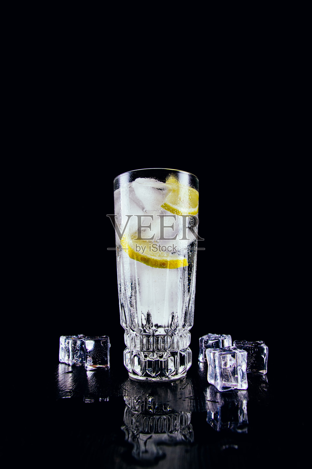 一杯杜松子酒加柠檬和冰块在黑色背景下照片摄影图片